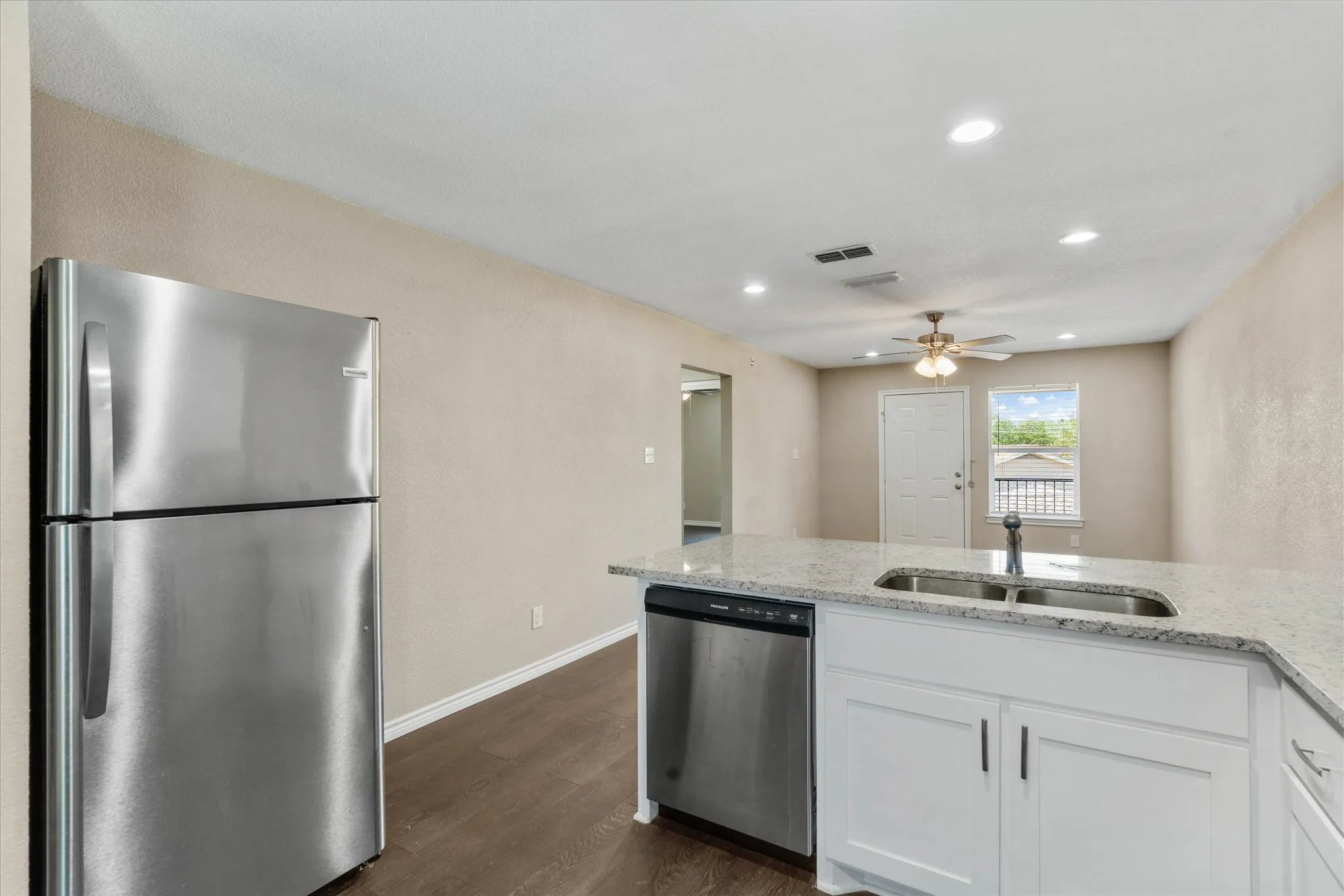 Kitchen featuring white cabinetry, dark wood-type flooring, ceiling fan, appliances with stainless steel finishes, and sink