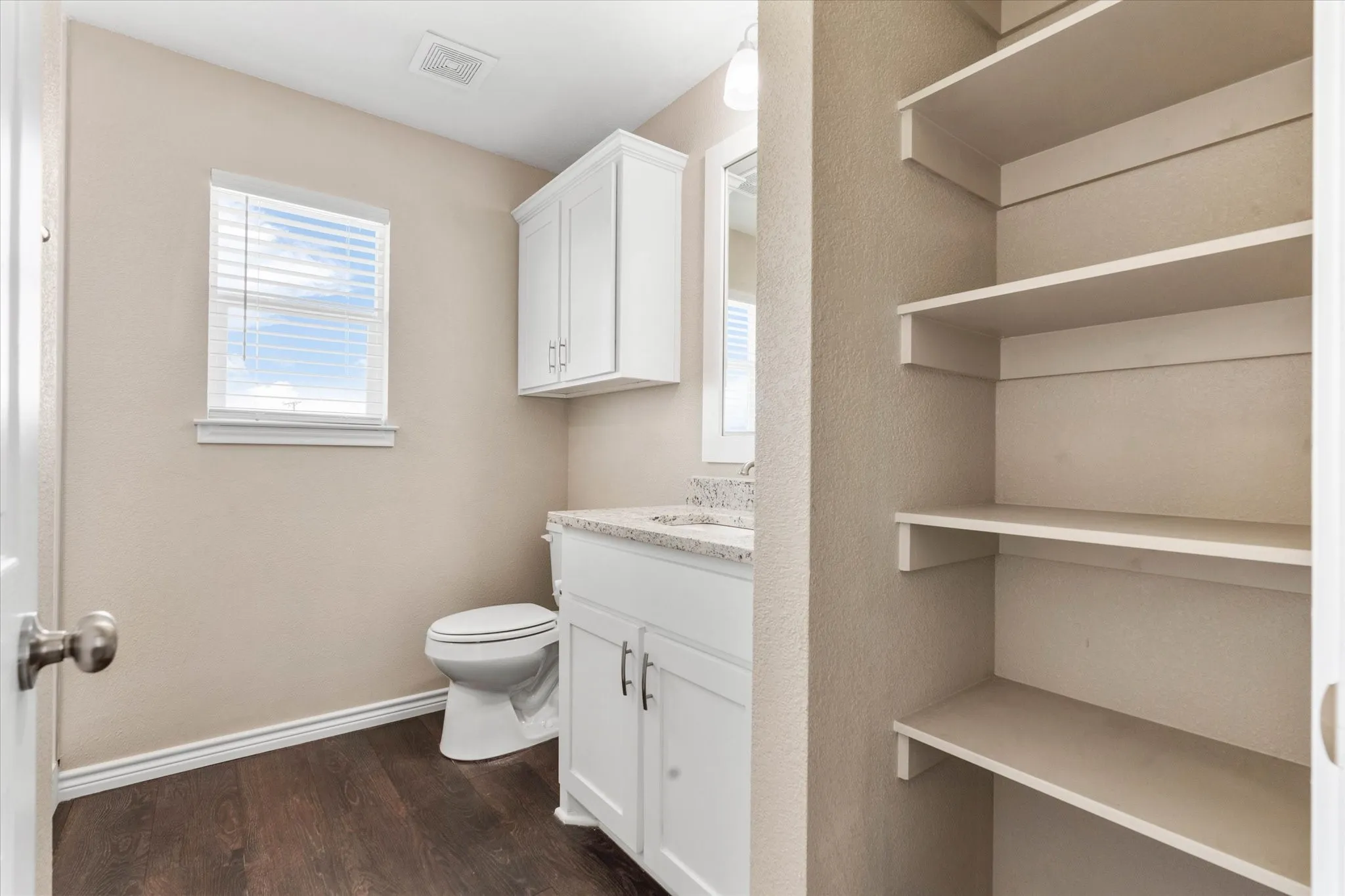Bathroom featuring vanity, hardwood / wood-style flooring, and toilet