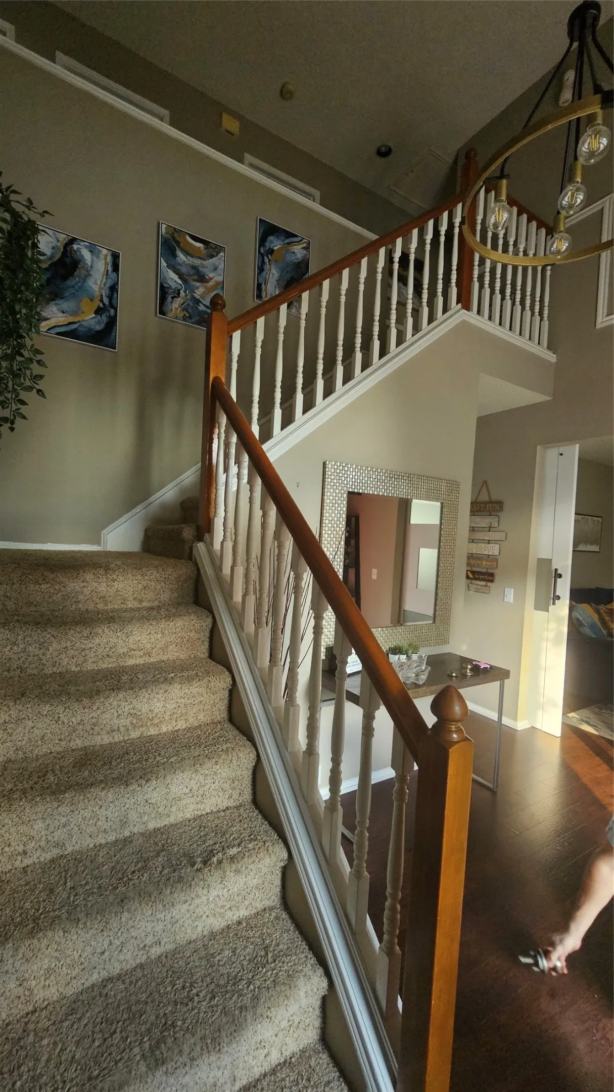 Carpeted staircase with wood handrails and white balusters
