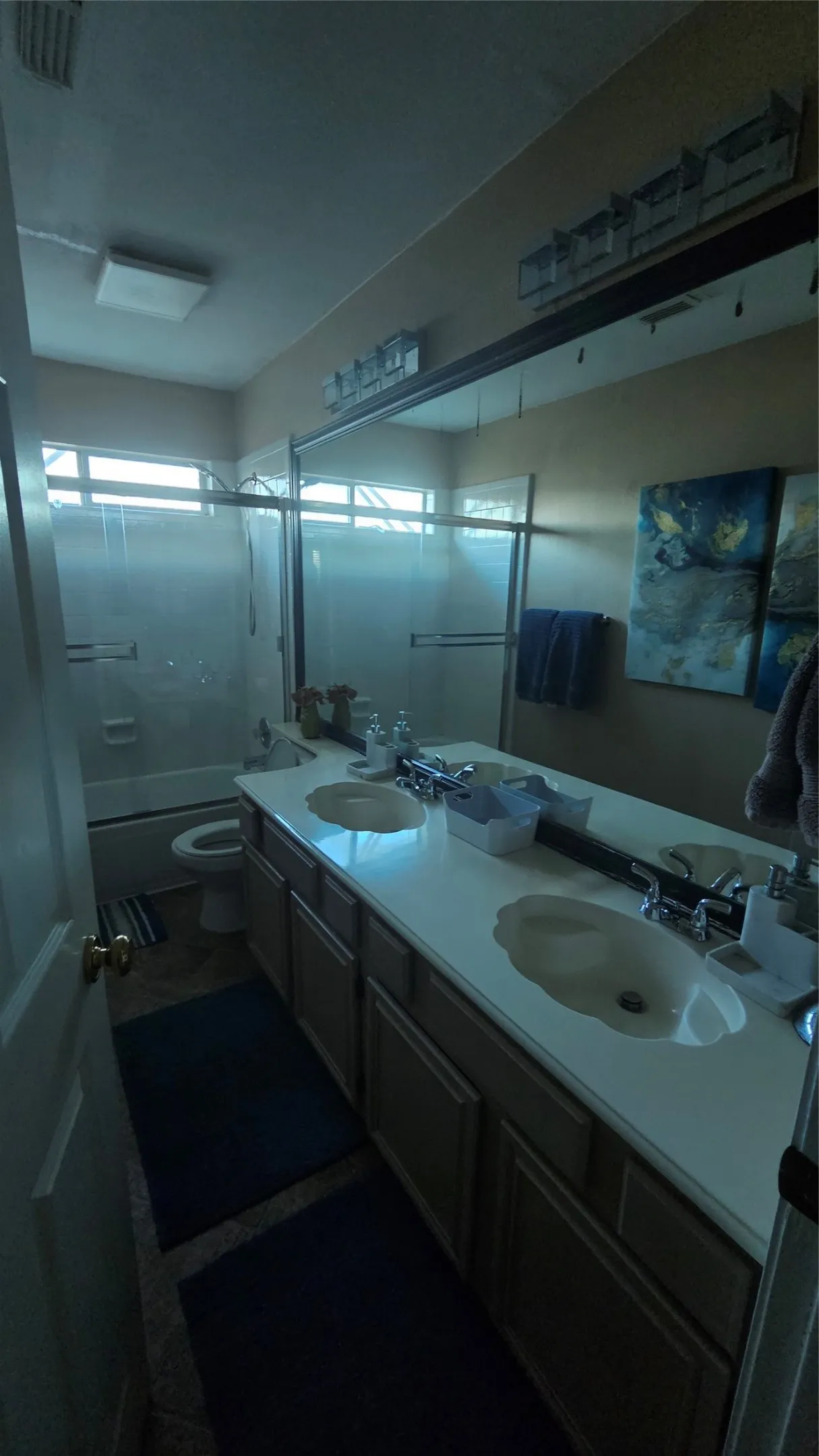 Dual vanity with white countertop, integrated sinks, and chrome faucets
