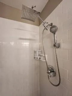 Subway tile surround featuring a rainfall showerhead and a handheld shower attachment