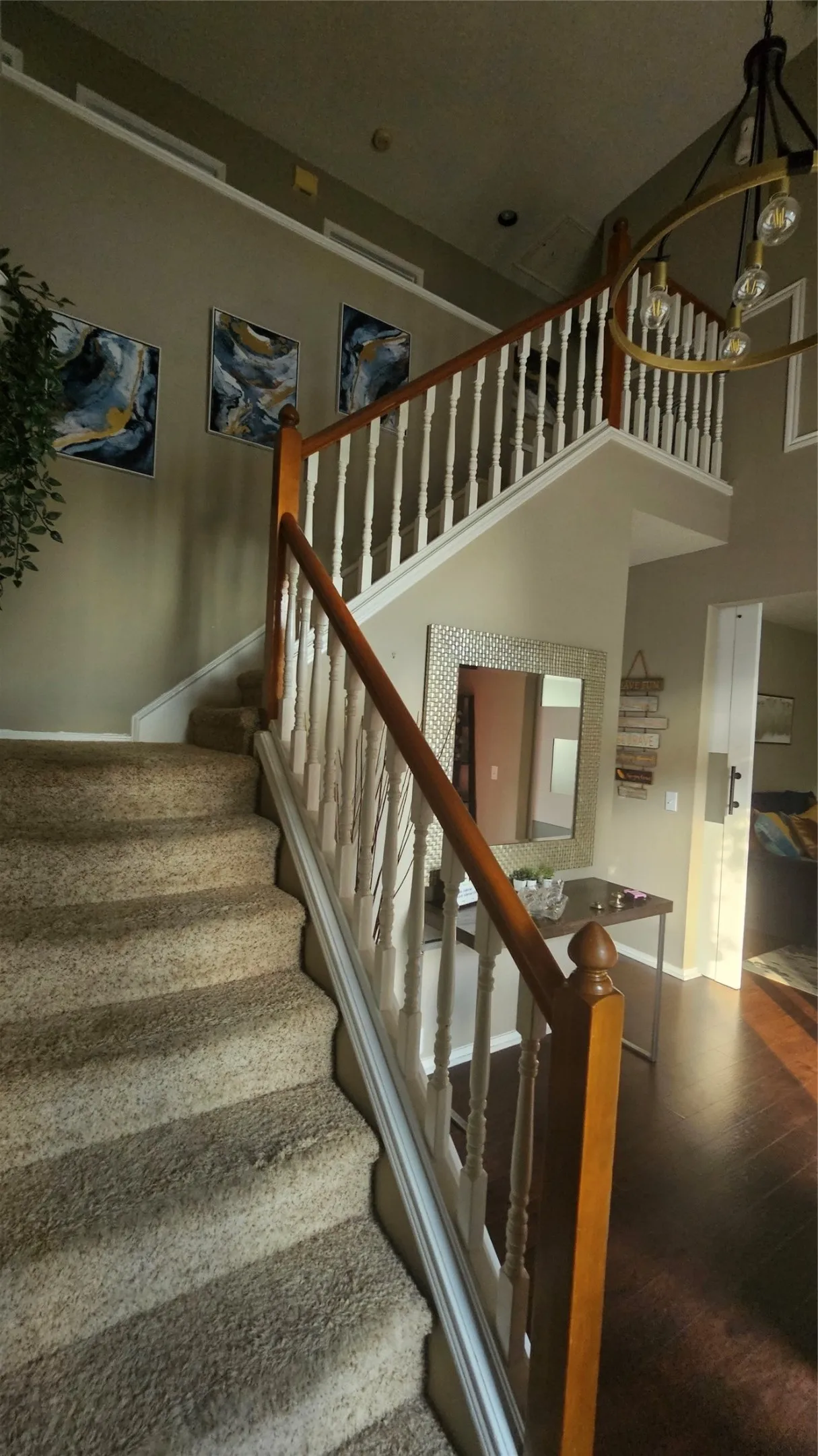 Grand staircase featuring wood railings and white balusters