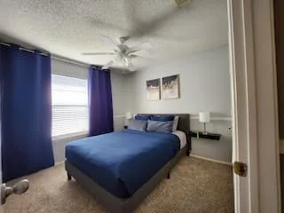 Window with blinds, wall-to-wall carpeting, and overhead ceiling fan