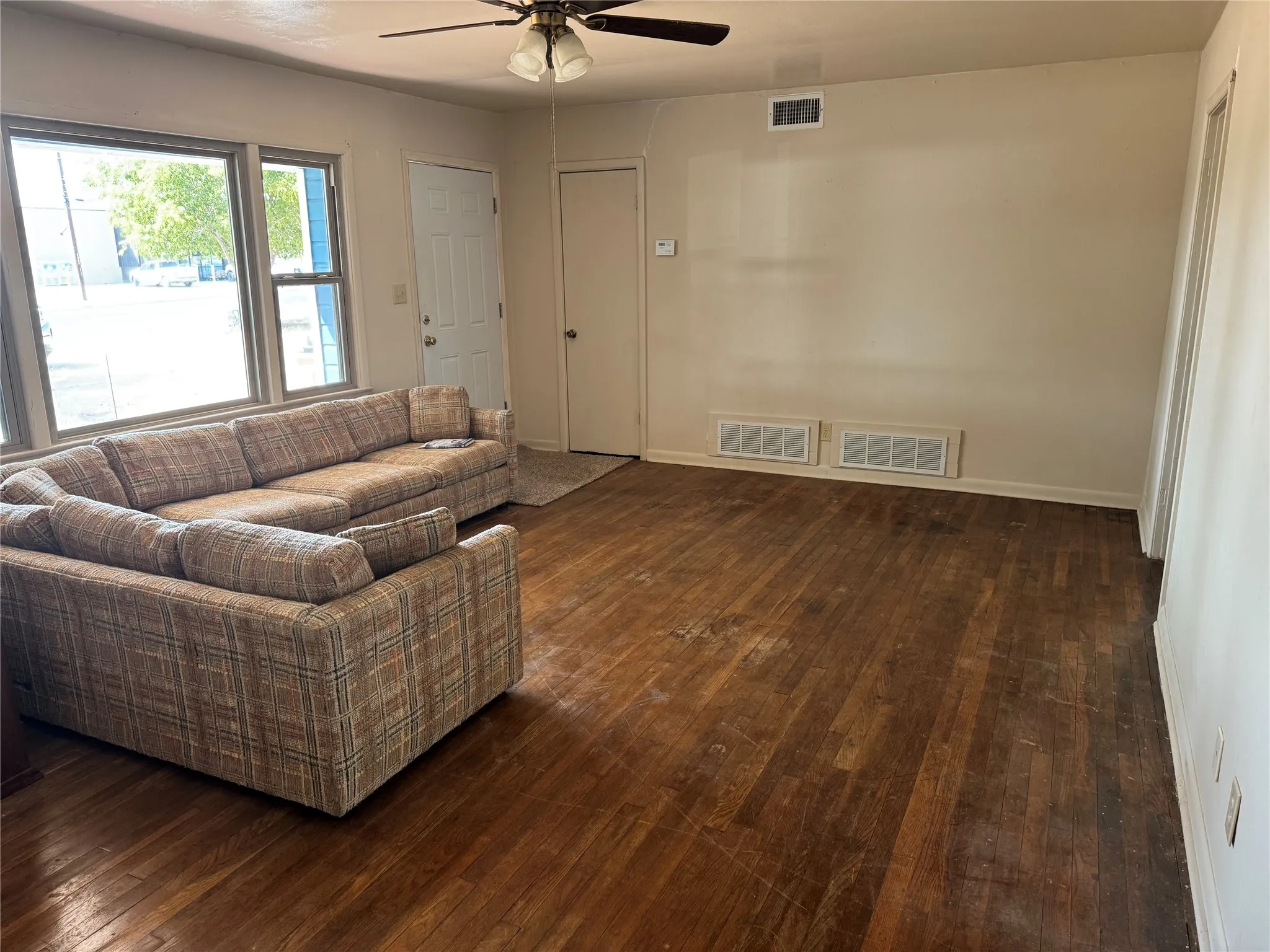 Spacious living area with wood floors and lots of natural light.