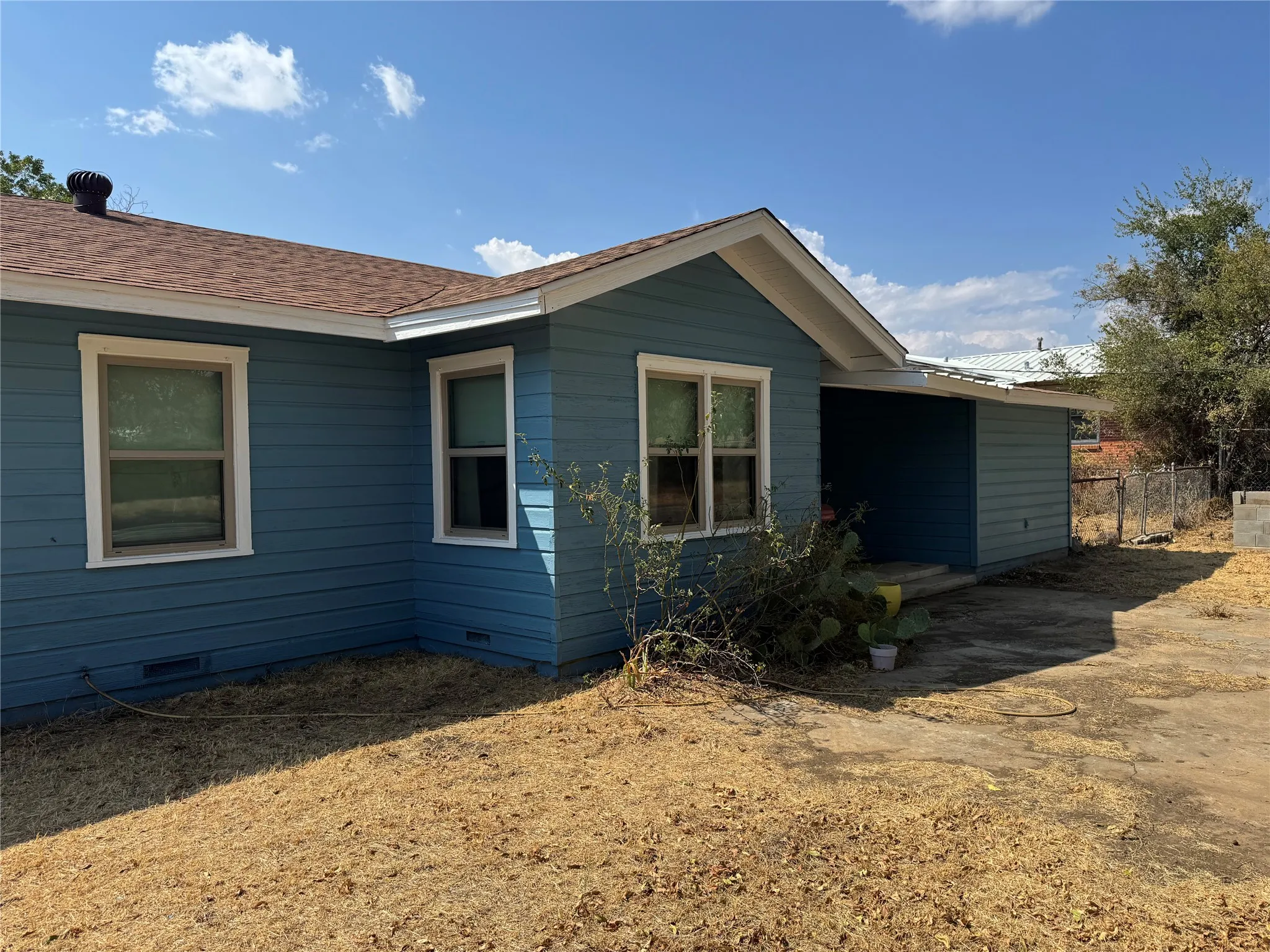 Back of house. Covered back porch. Large lot with pipe fence.