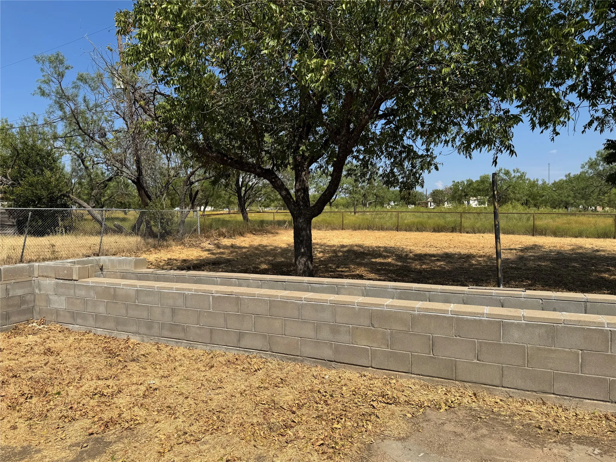 Raised bed flower-gardening beds. Great pecan-producing trees. Large lot with pipe fence.