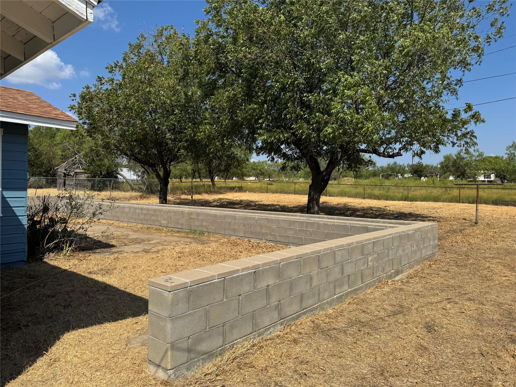 Raised bed flower-gardening beds. Great pecan-producing trees. Large lot with pipe fence.