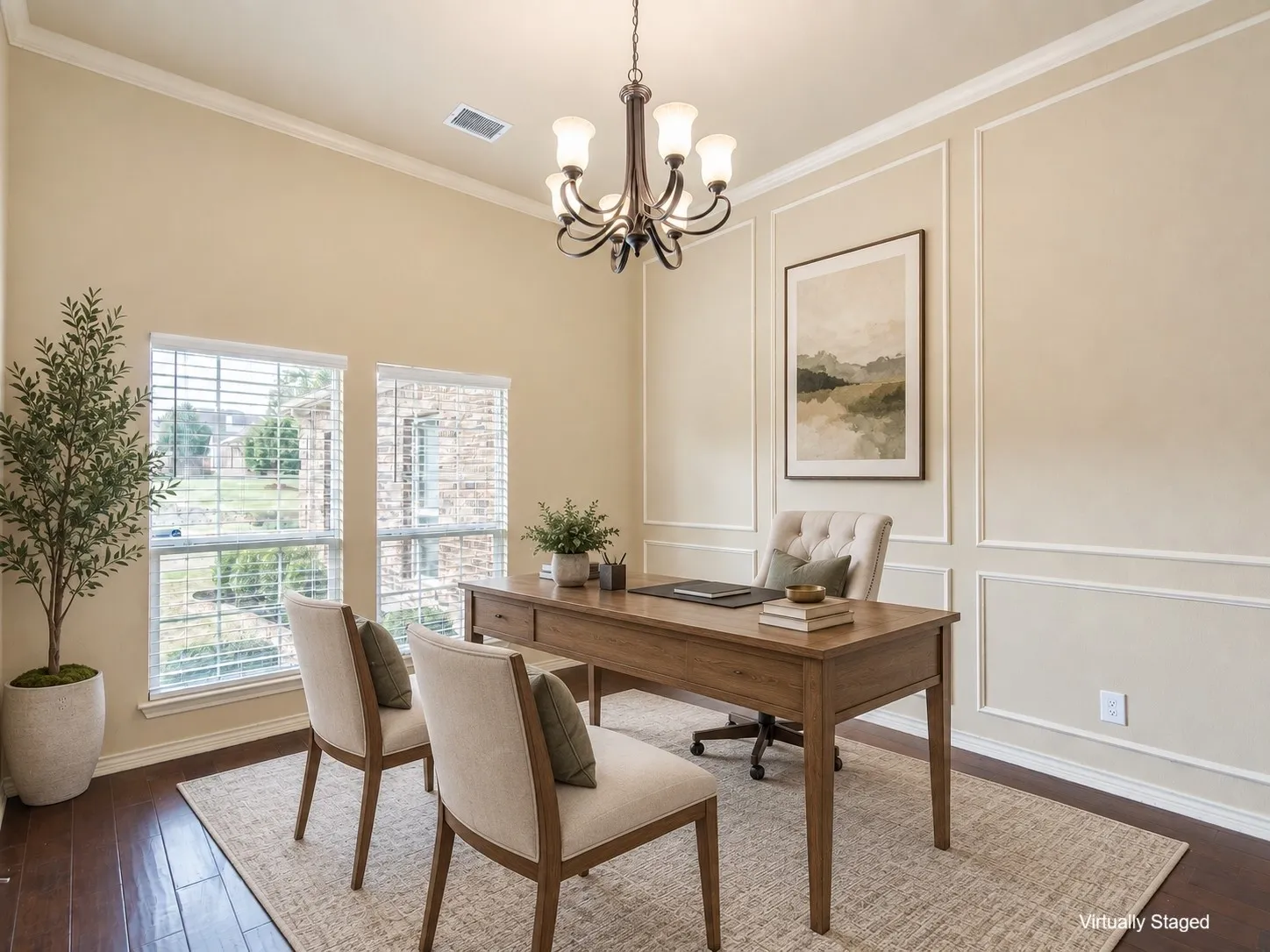Wood-finish flooring, crown molding, wall paneling, and an elegant chandelier complement the two large windows