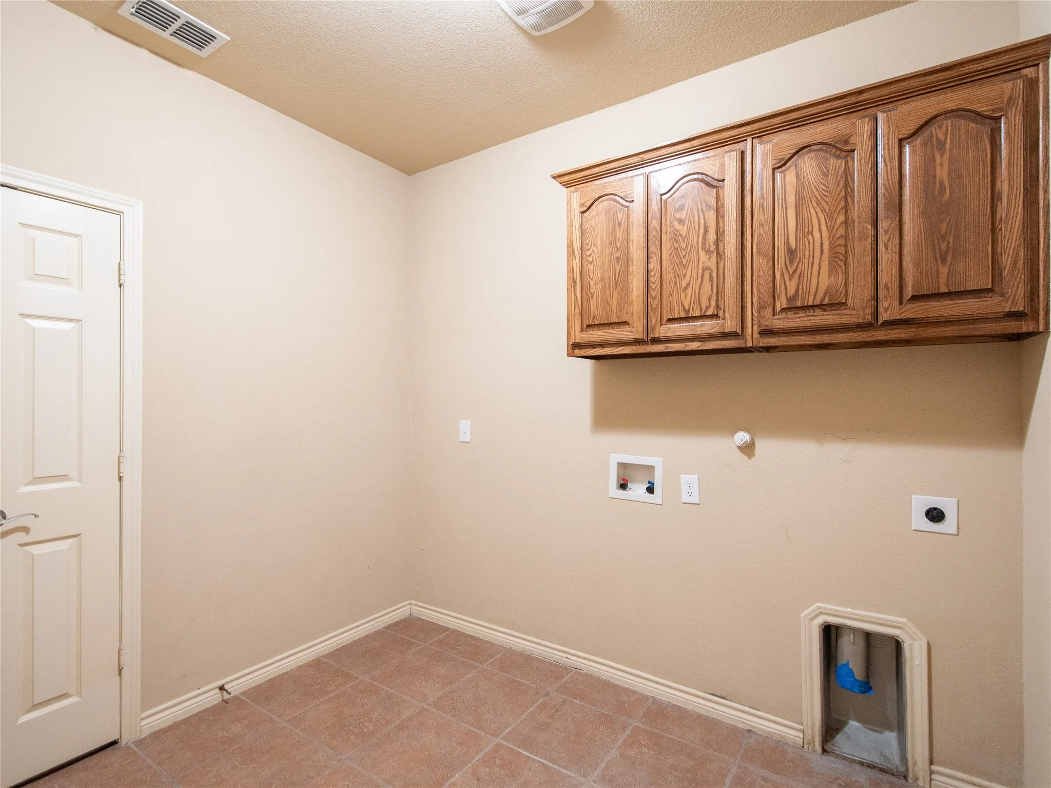 Built-in wood-finish cabinetry, tile flooring, and a paneled door