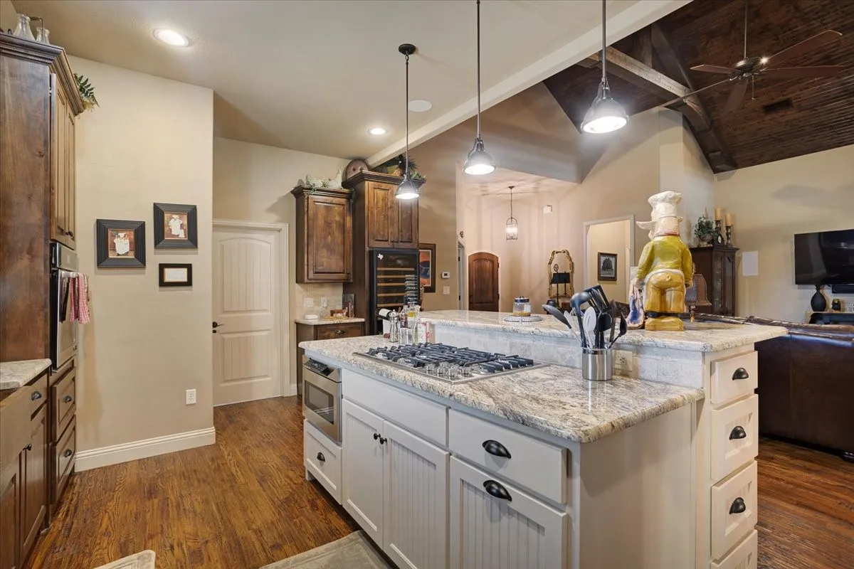 Wood-finish flooring, recessed lighting, and a vaulted ceiling with exposed beams