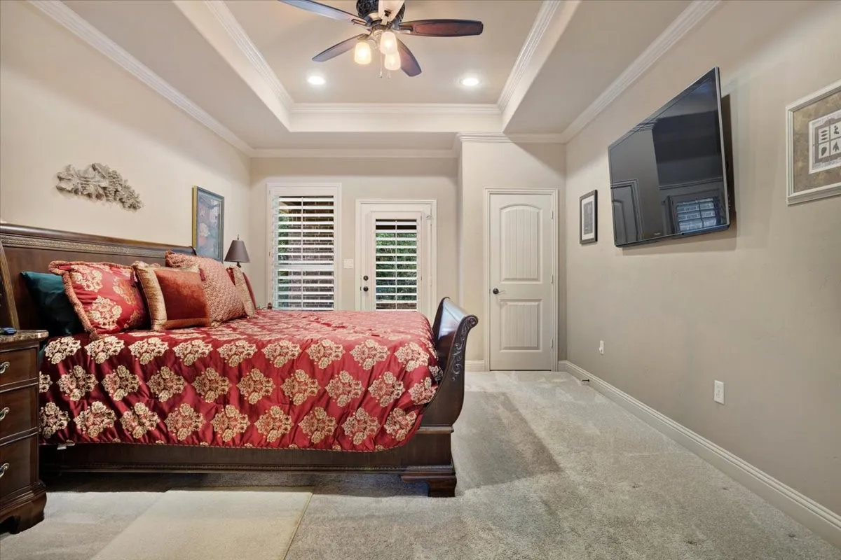 Tray ceiling with recessed lighting, ceiling fan, and crown molding