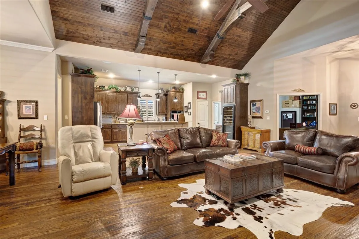 Vaulted wood-finish ceiling with exposed beams, wood-finish flooring, recessed lighting, and built-in cabinetry