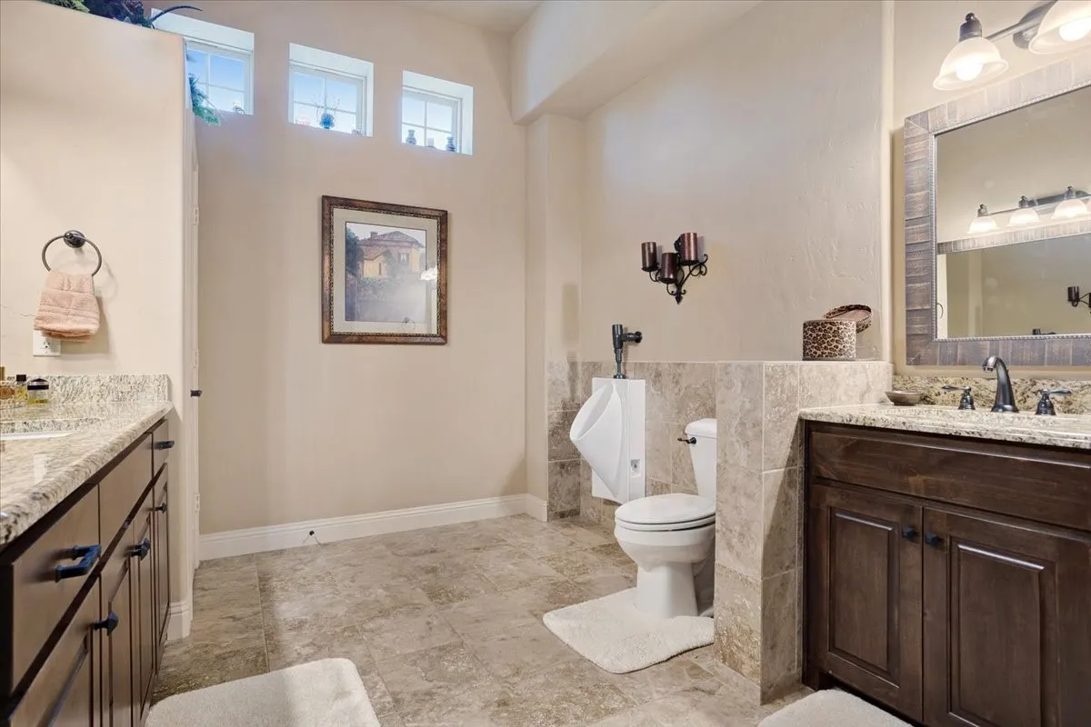 Dual vanity with granite countertops and dark wood cabinetry