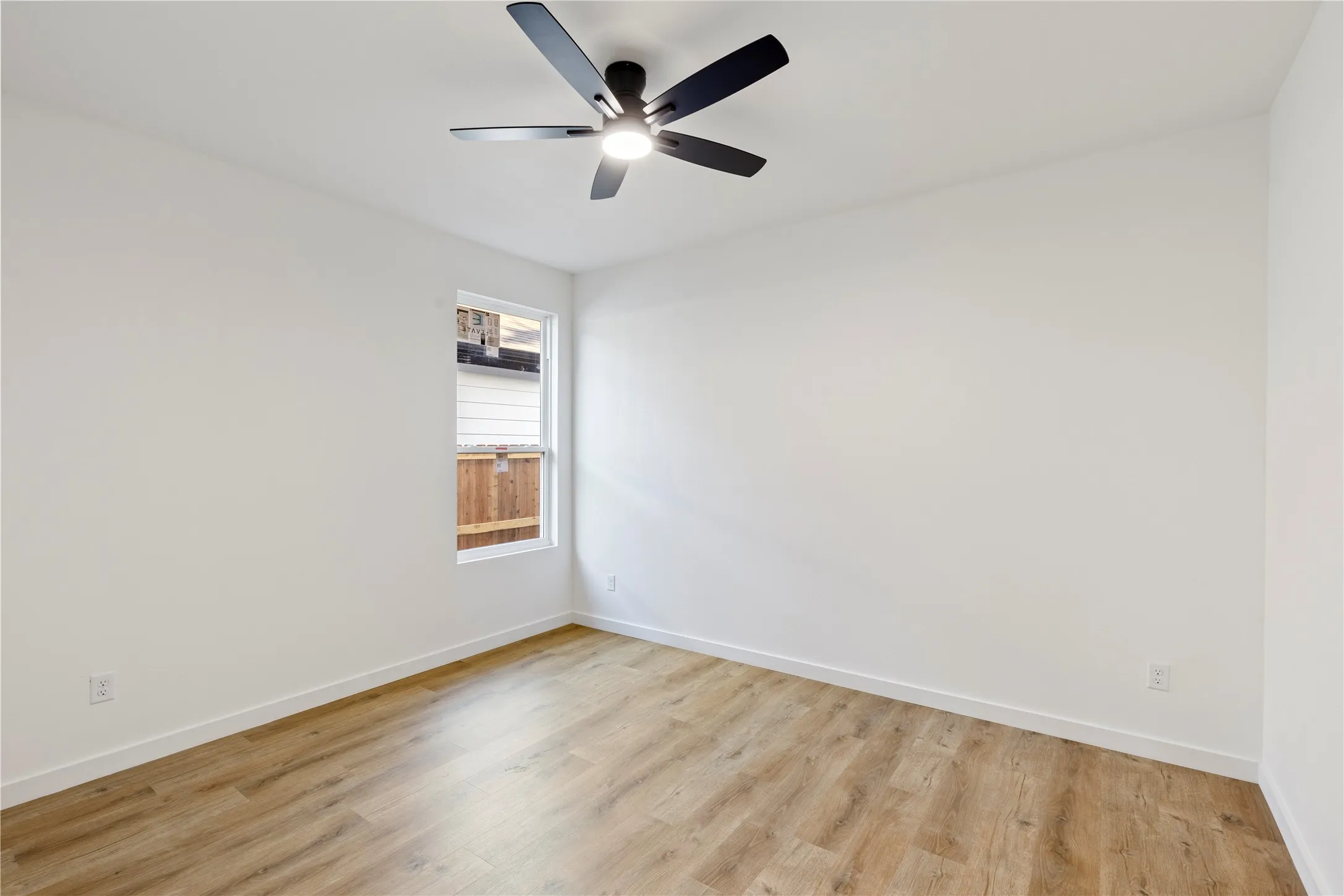 Room with wood-finish flooring, a contemporary ceiling fan, and a single window