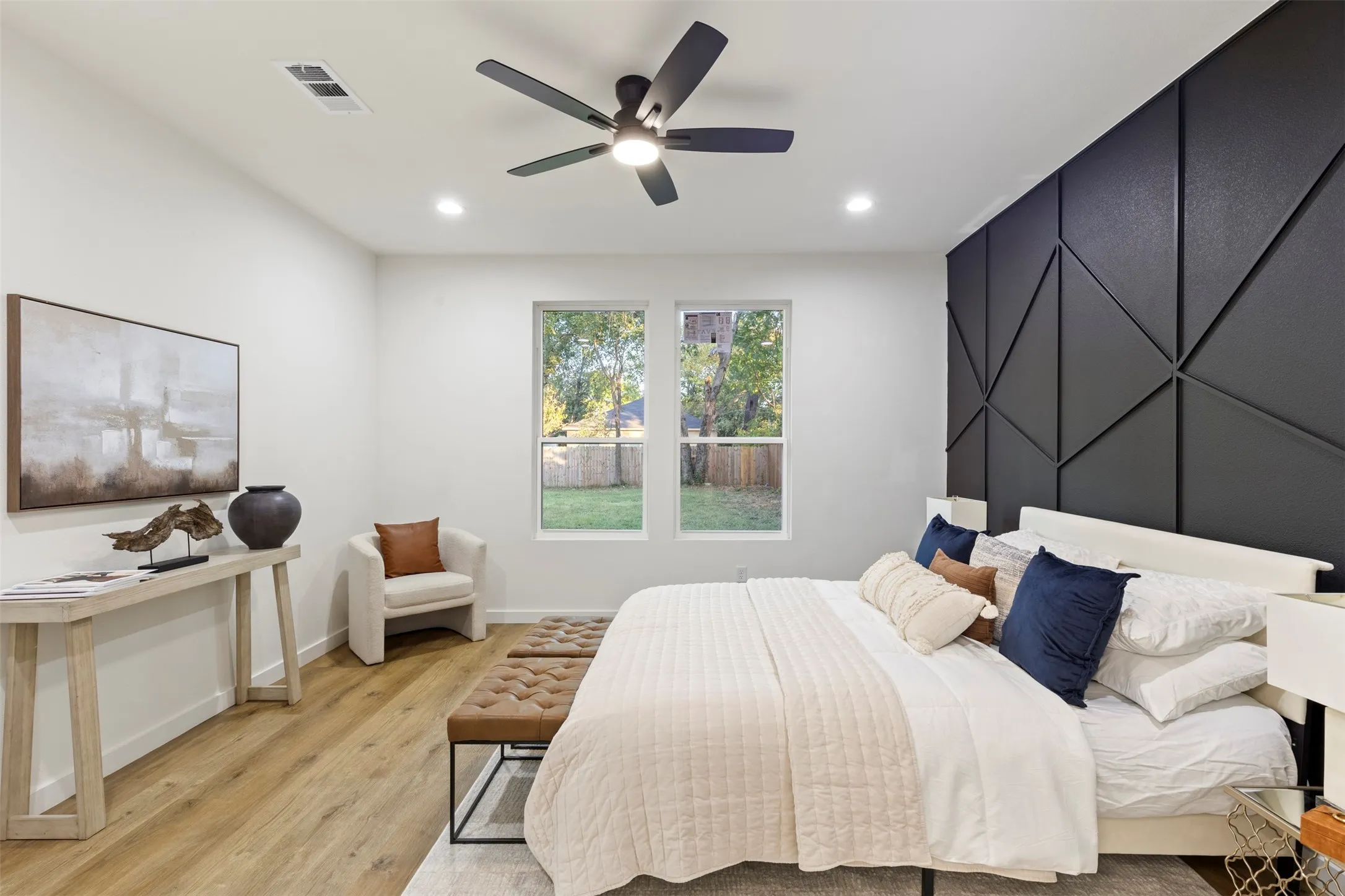 Recessed lighting, wood-finish flooring, and a ceiling fan with integrated lighting