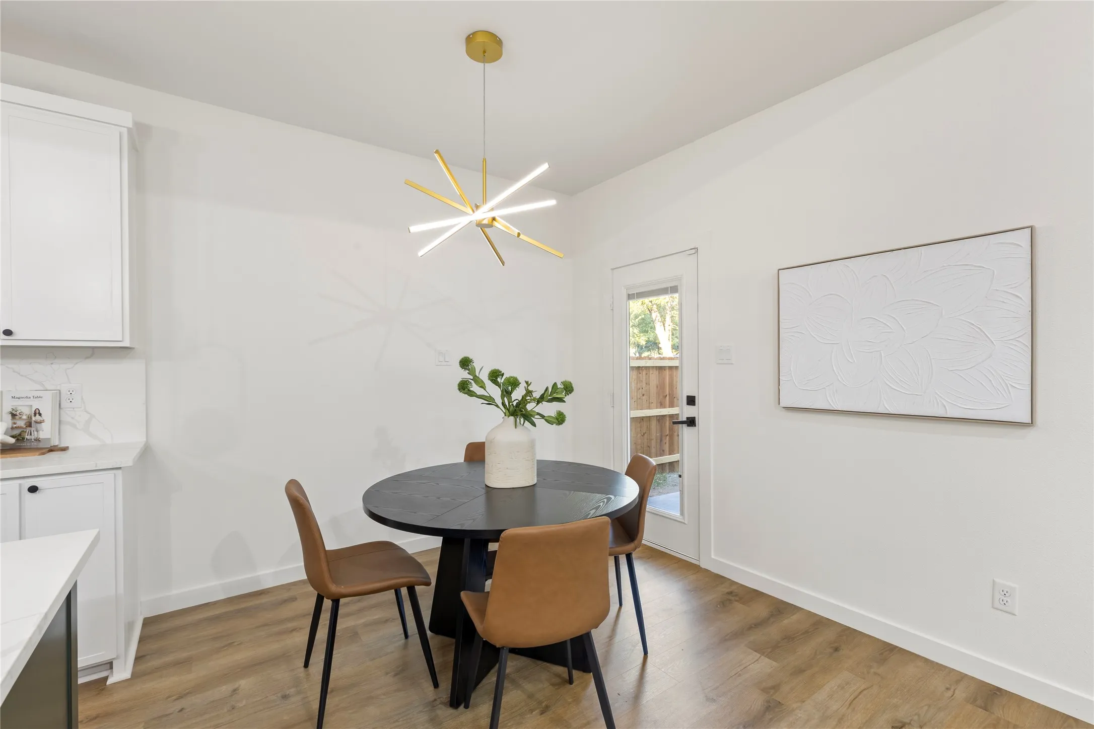 Wood-finish flooring, white walls, and a modern gold-tone light fixture illuminate the space