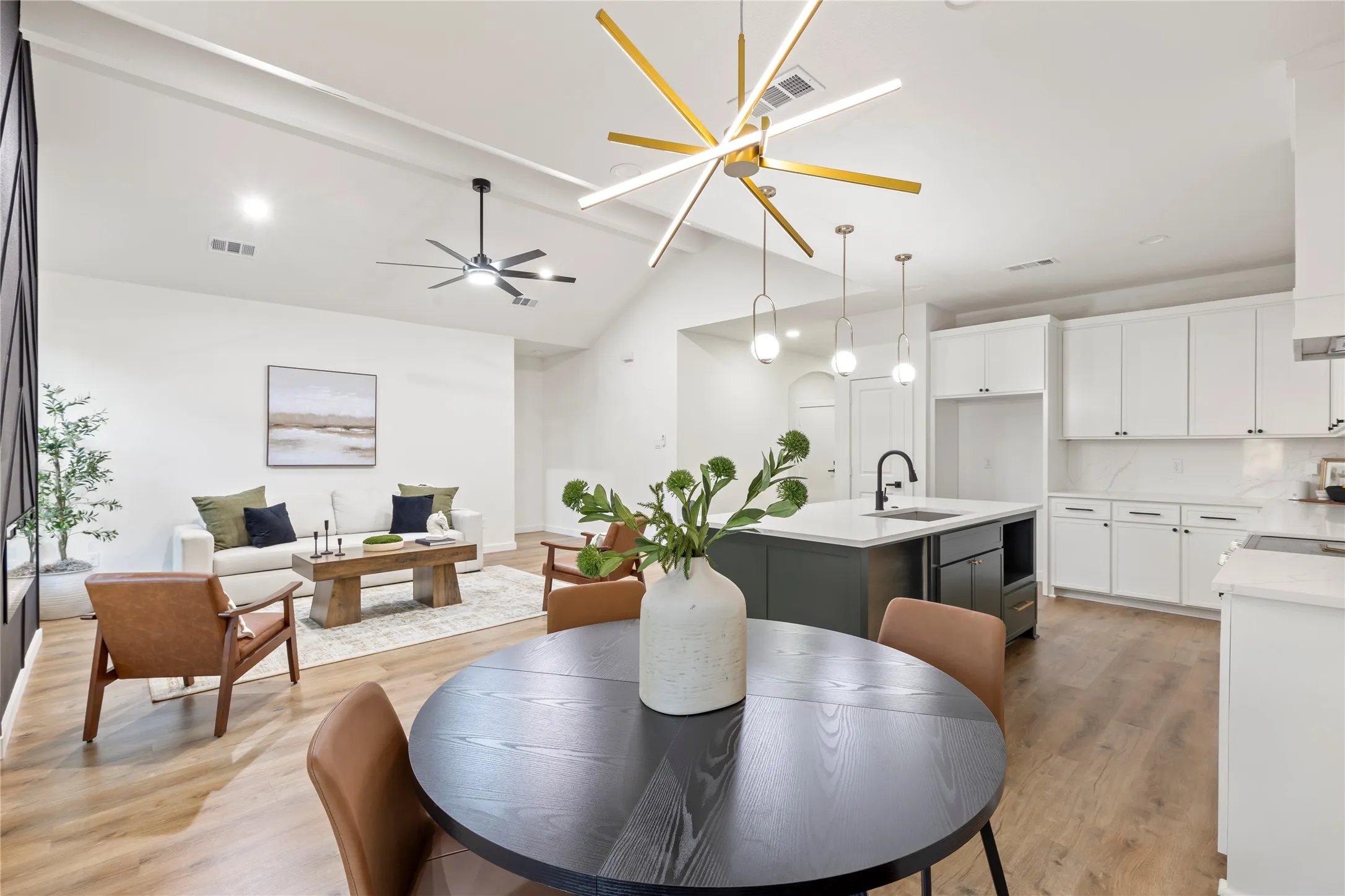 Vaulted ceiling with an architectural light fixture and recessed lighting