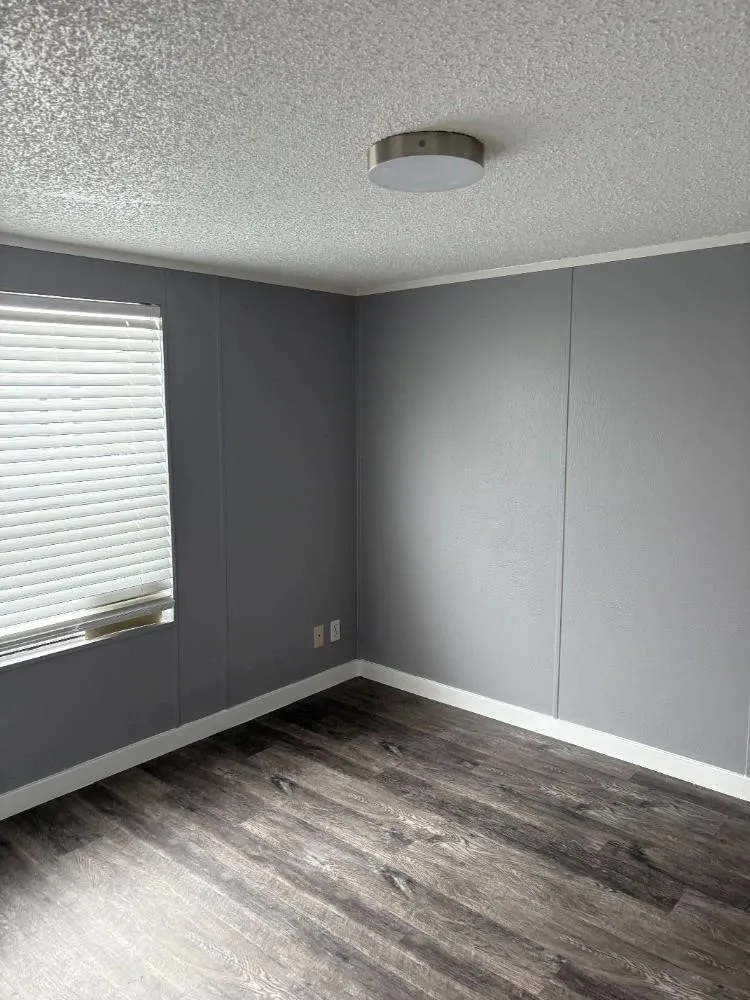 Wood-finish flooring with a neutral paint palette and window blinds