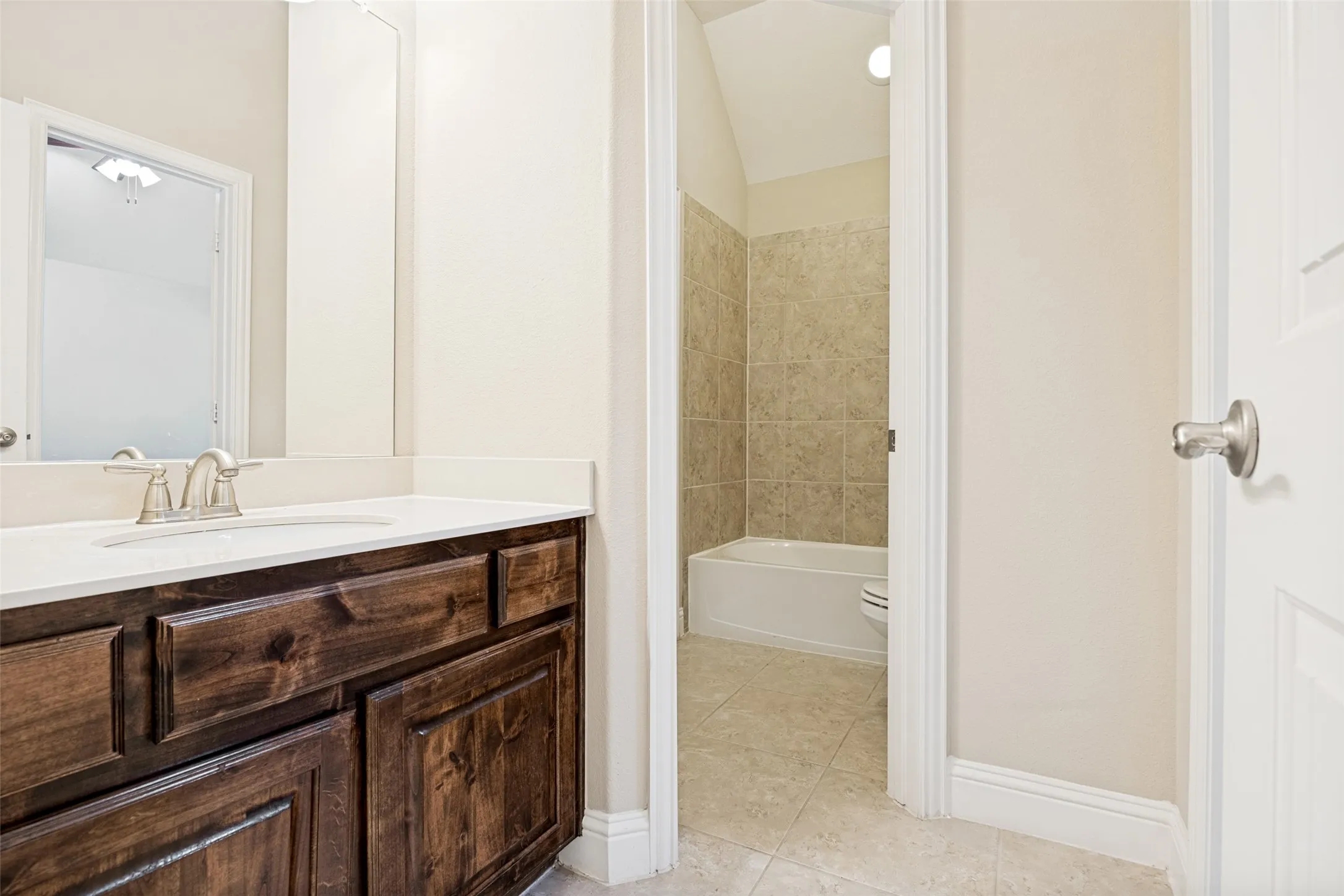 Dark wood-finish vanity with a white countertop and undermount sink