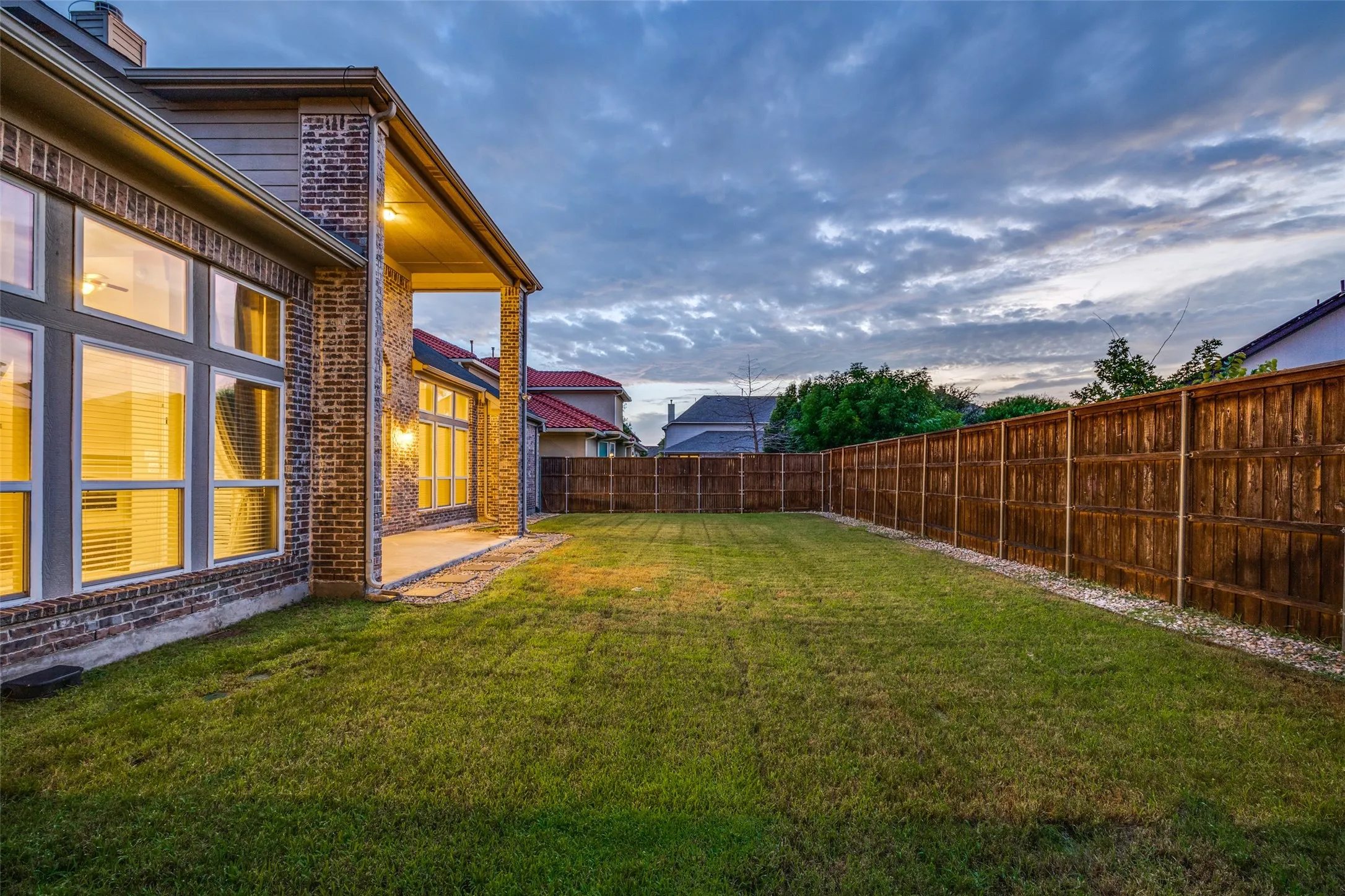 Expansive grass lawn with a full privacy fence