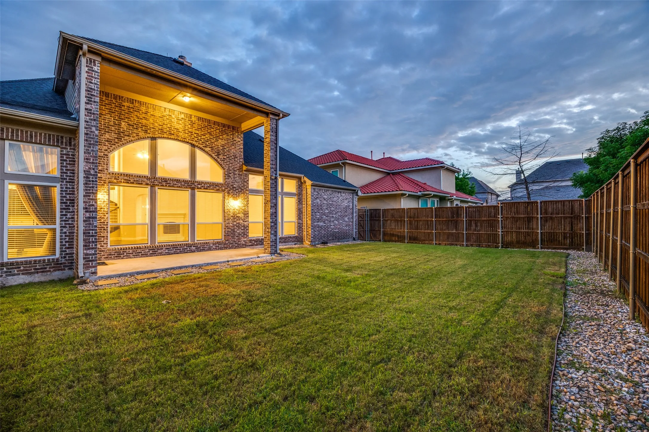 Expansive lawn with a wooden privacy fence and a gravel border
