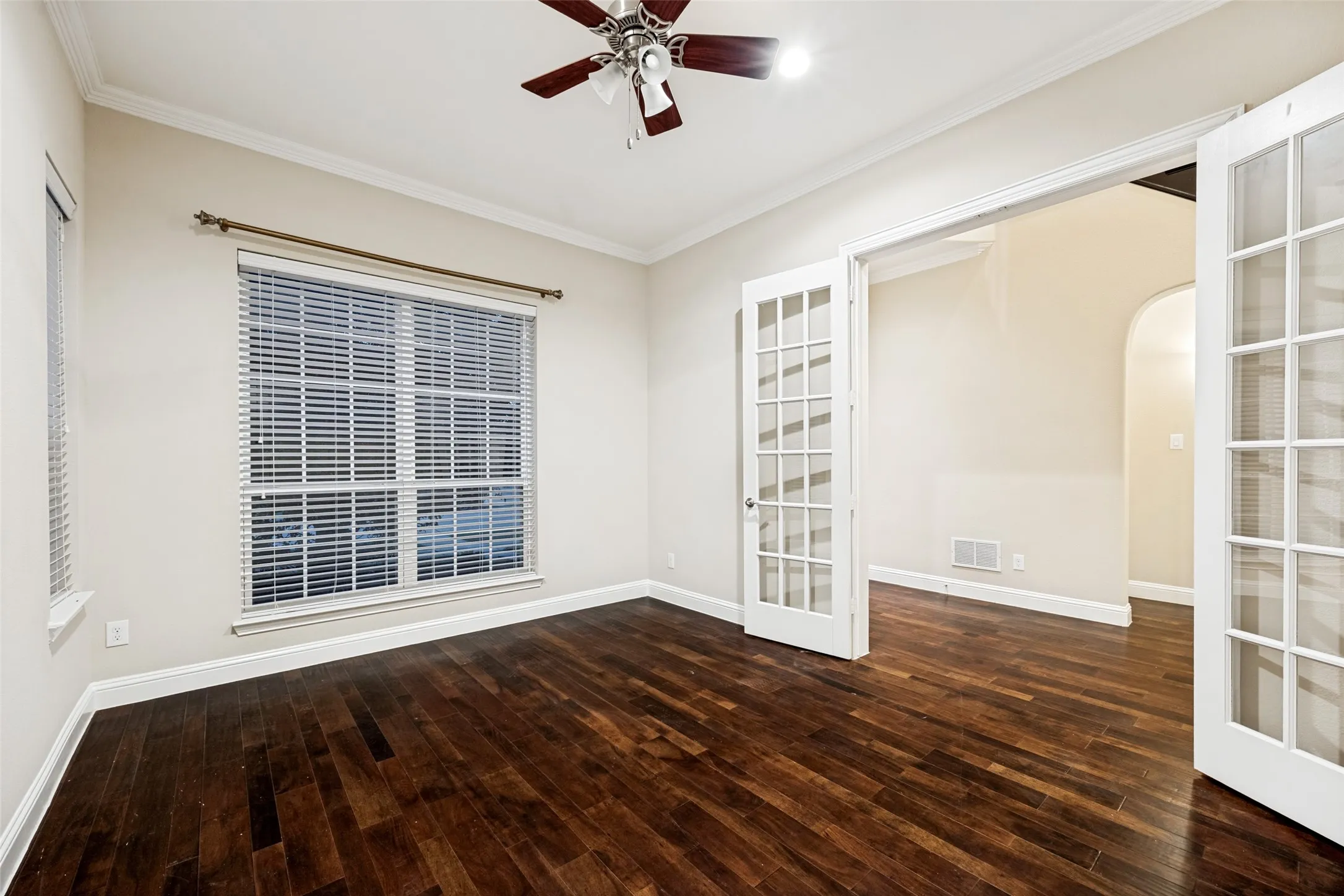 Hardwood flooring, French doors, crown molding, ceiling fan with light fixture, and window with blinds