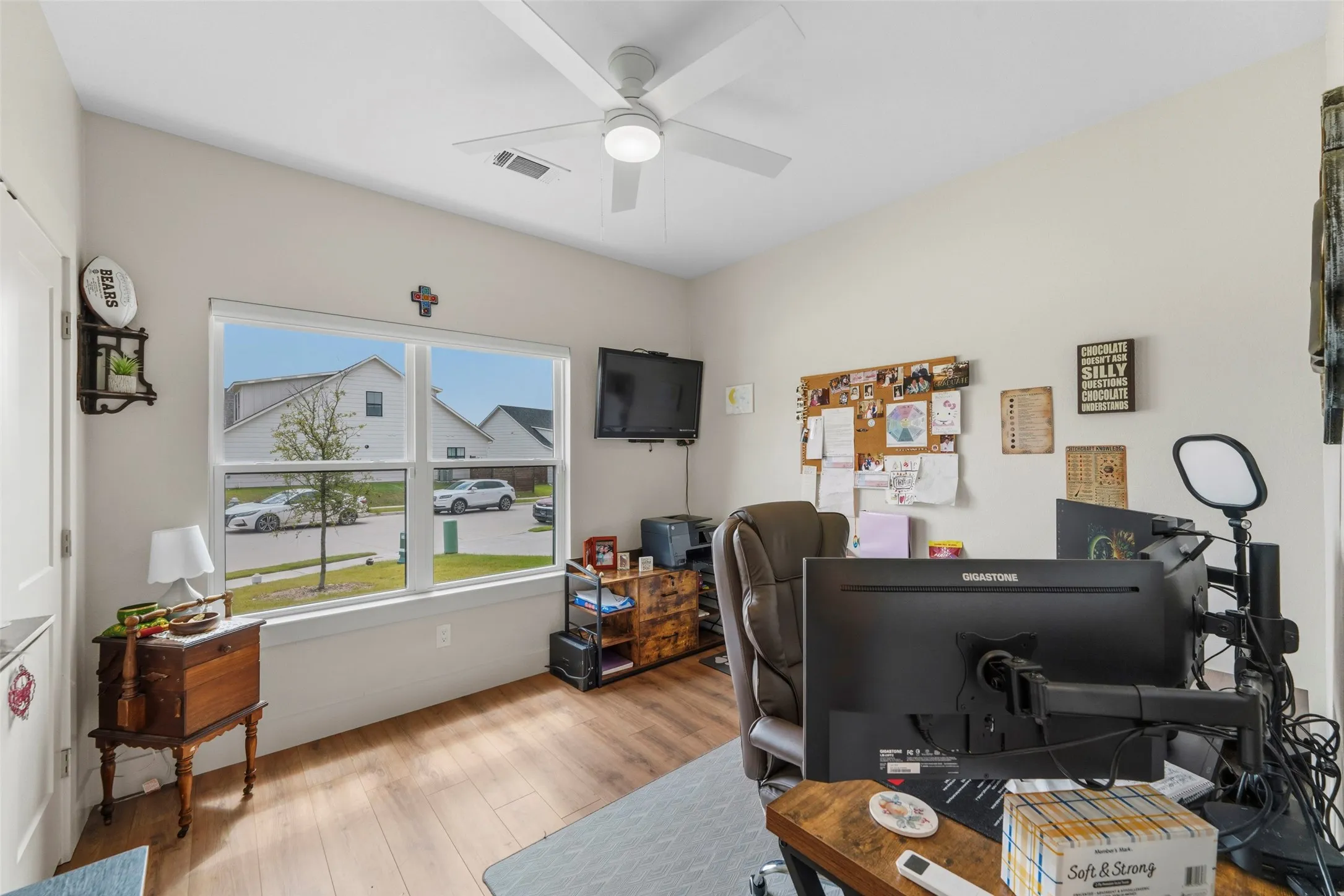 Interior room featuring light neutral walls, wood-finish flooring, and a contemporary ceiling fan with integrated lighting