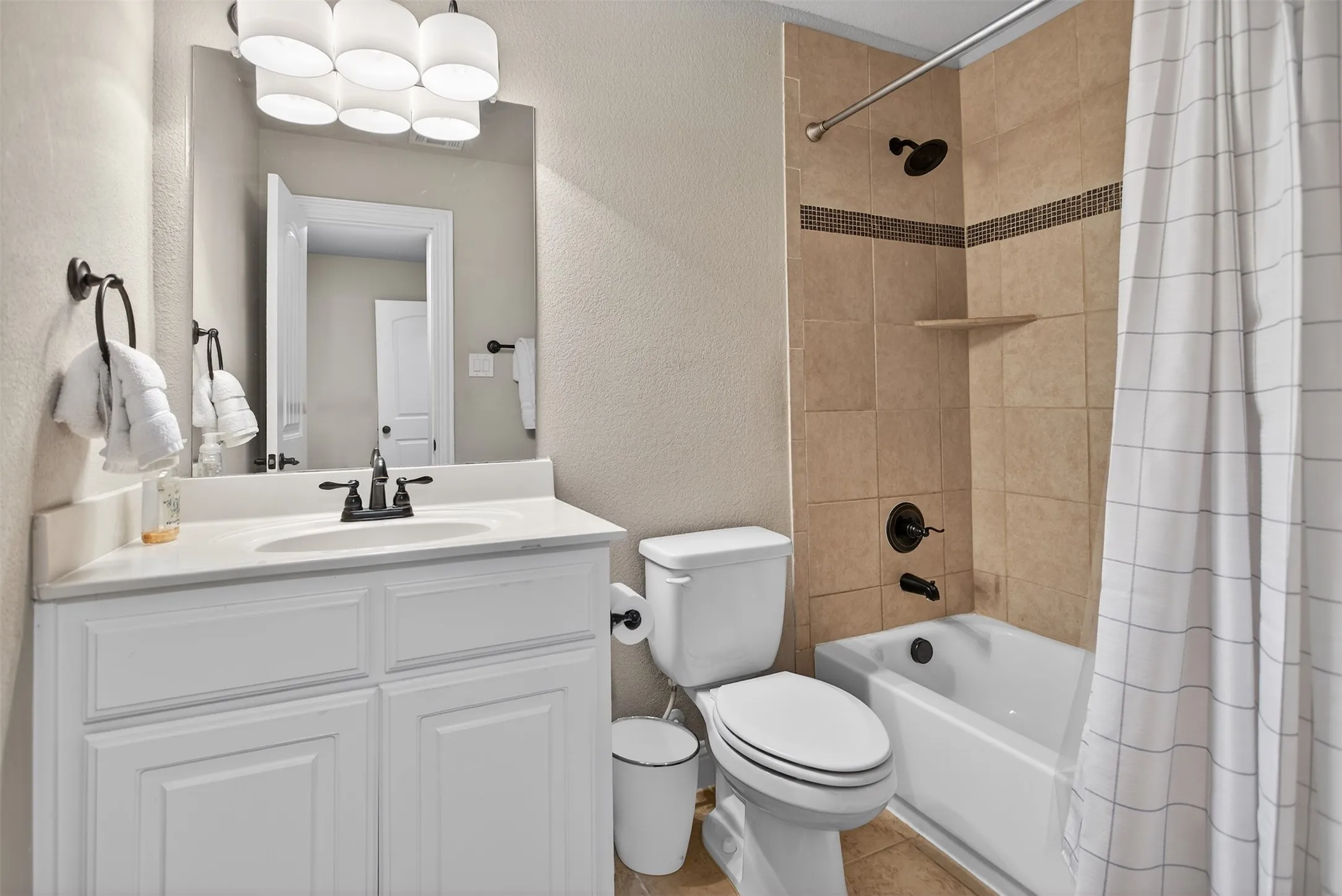 White vanity with cabinet storage, integrated sink, and dark bronze faucet