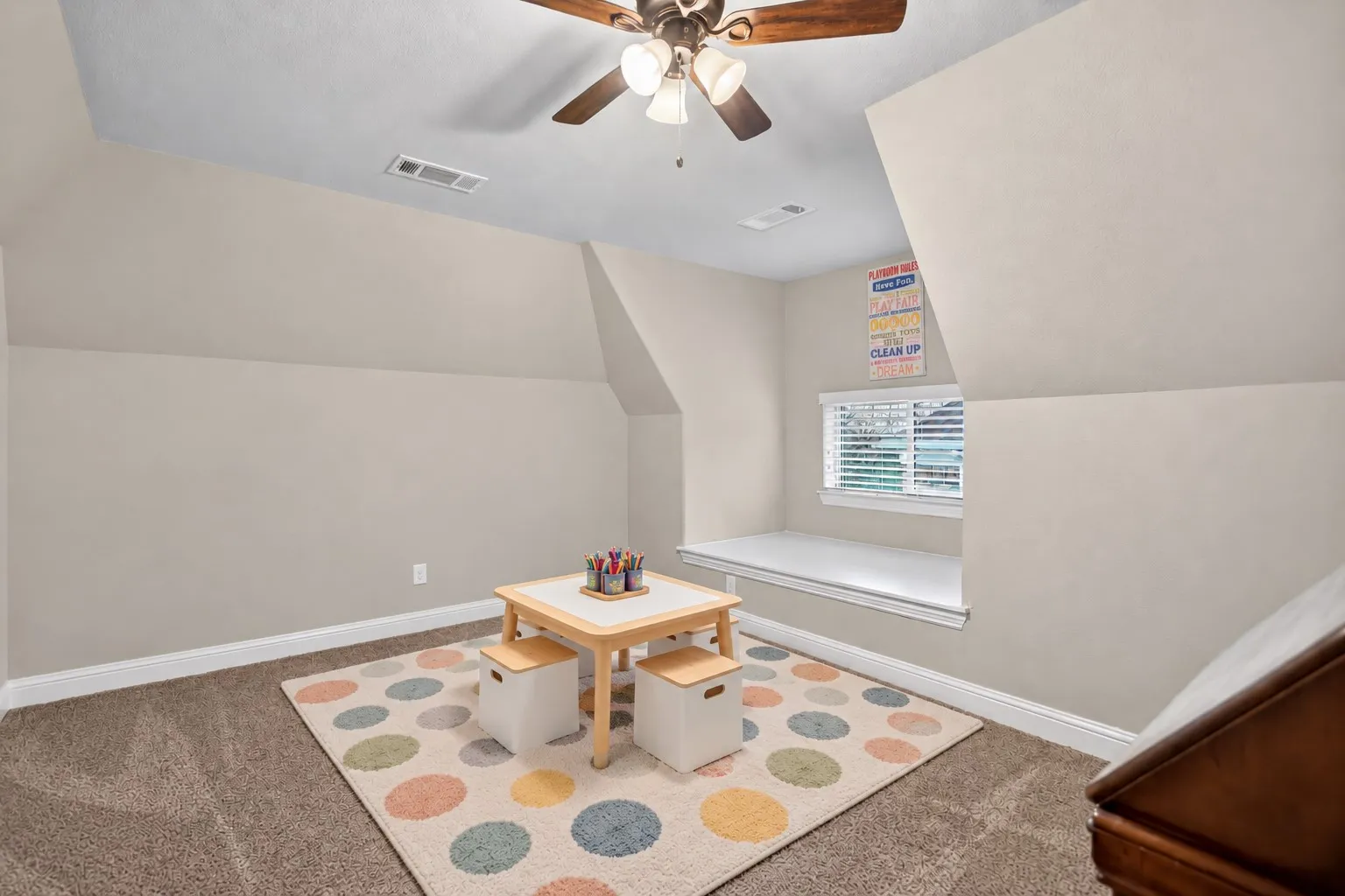 Carpeted flooring, sloped ceilings, ceiling fan with integrated lighting, window with blinds, and a built-in window seat
