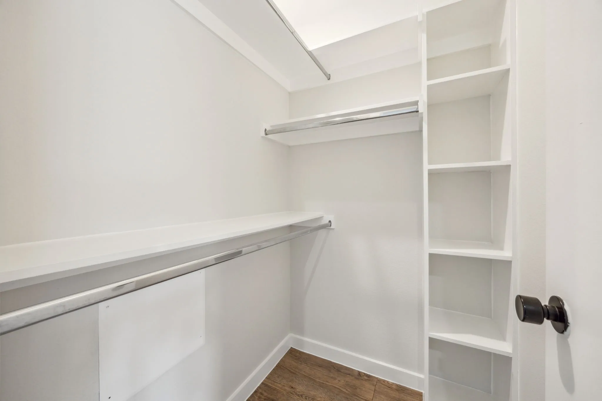 Integrated shelving, multiple hanging rods, and wood-finish flooring