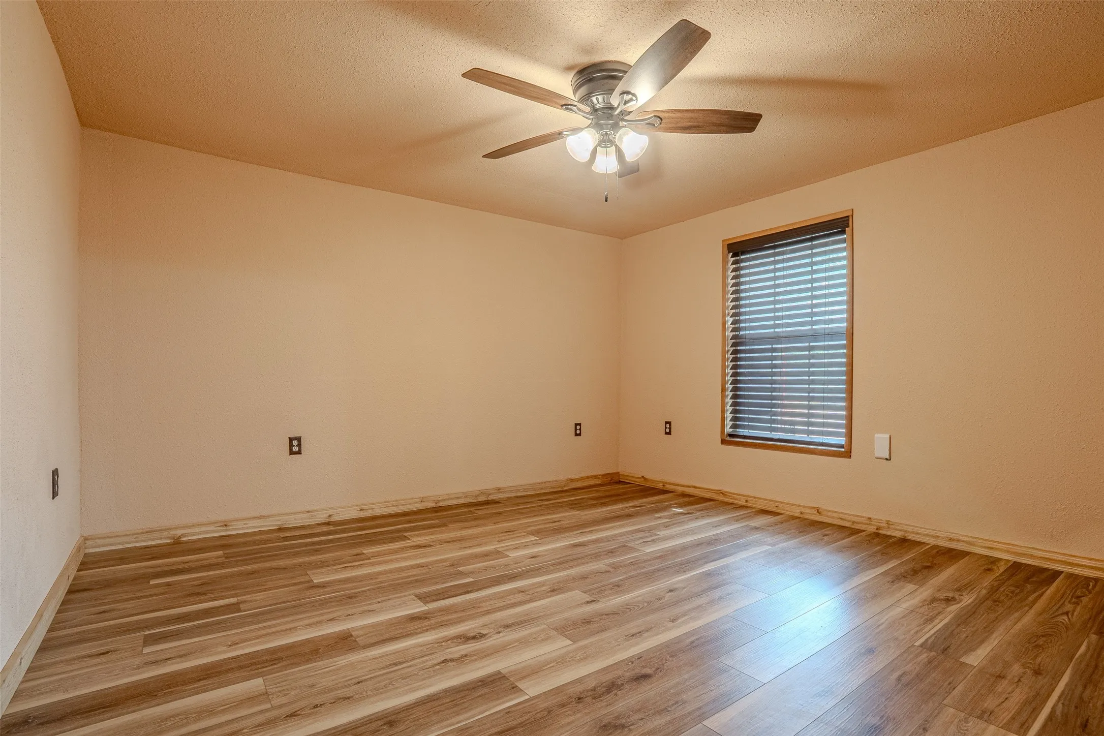 Wood-finish flooring throughout, complemented by a ceiling fan with integrated lighting