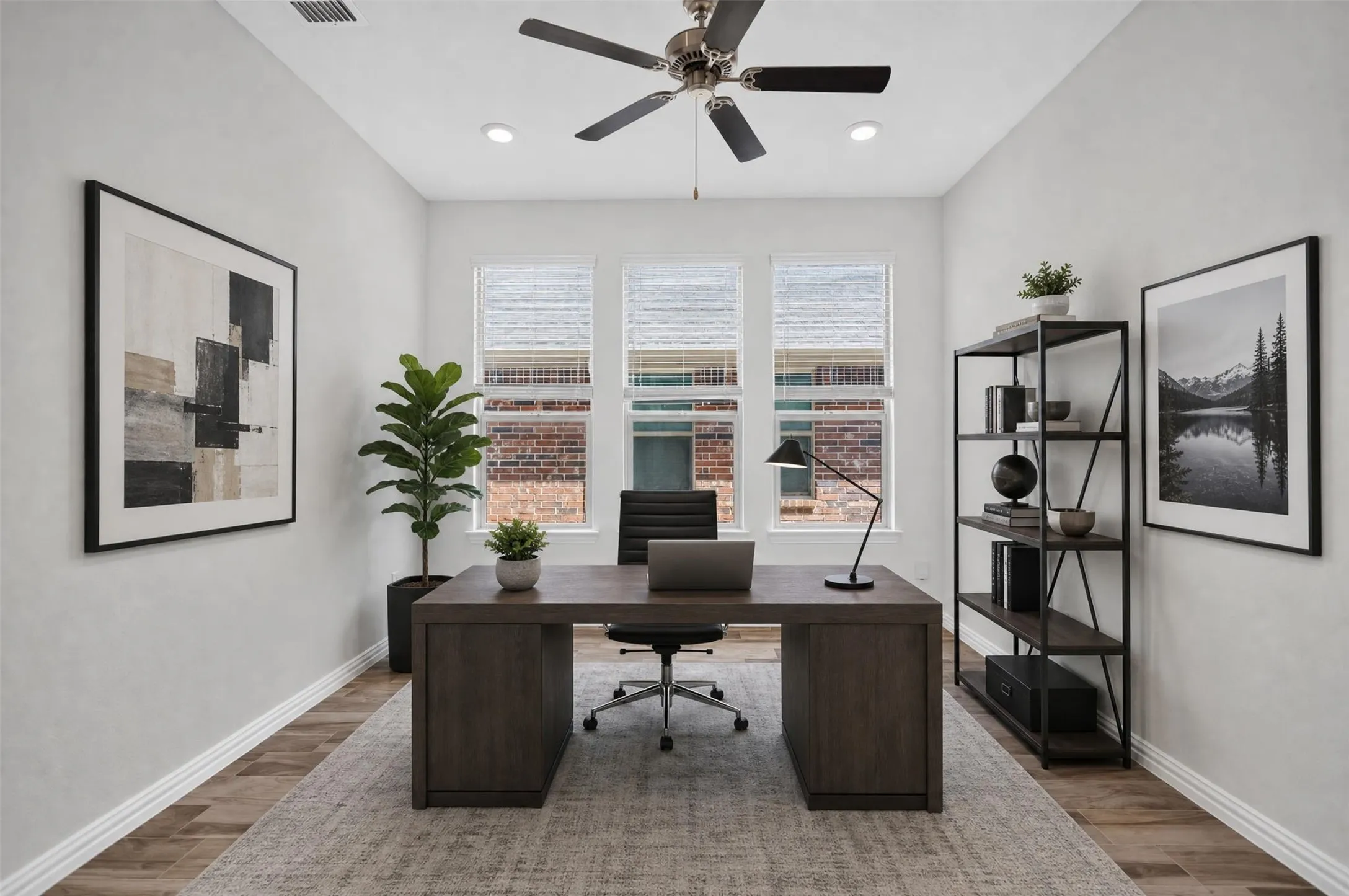 Recessed lighting, ceiling fan, three windows with blinds, and wood-finish flooring