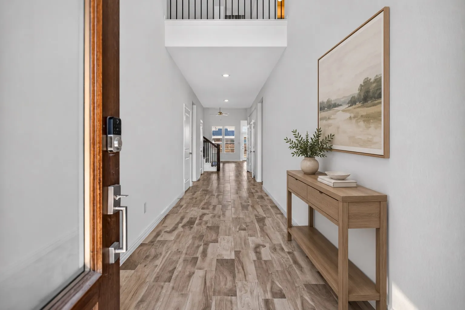 Wood-finish flooring throughout the hallway, with a two-story entryway