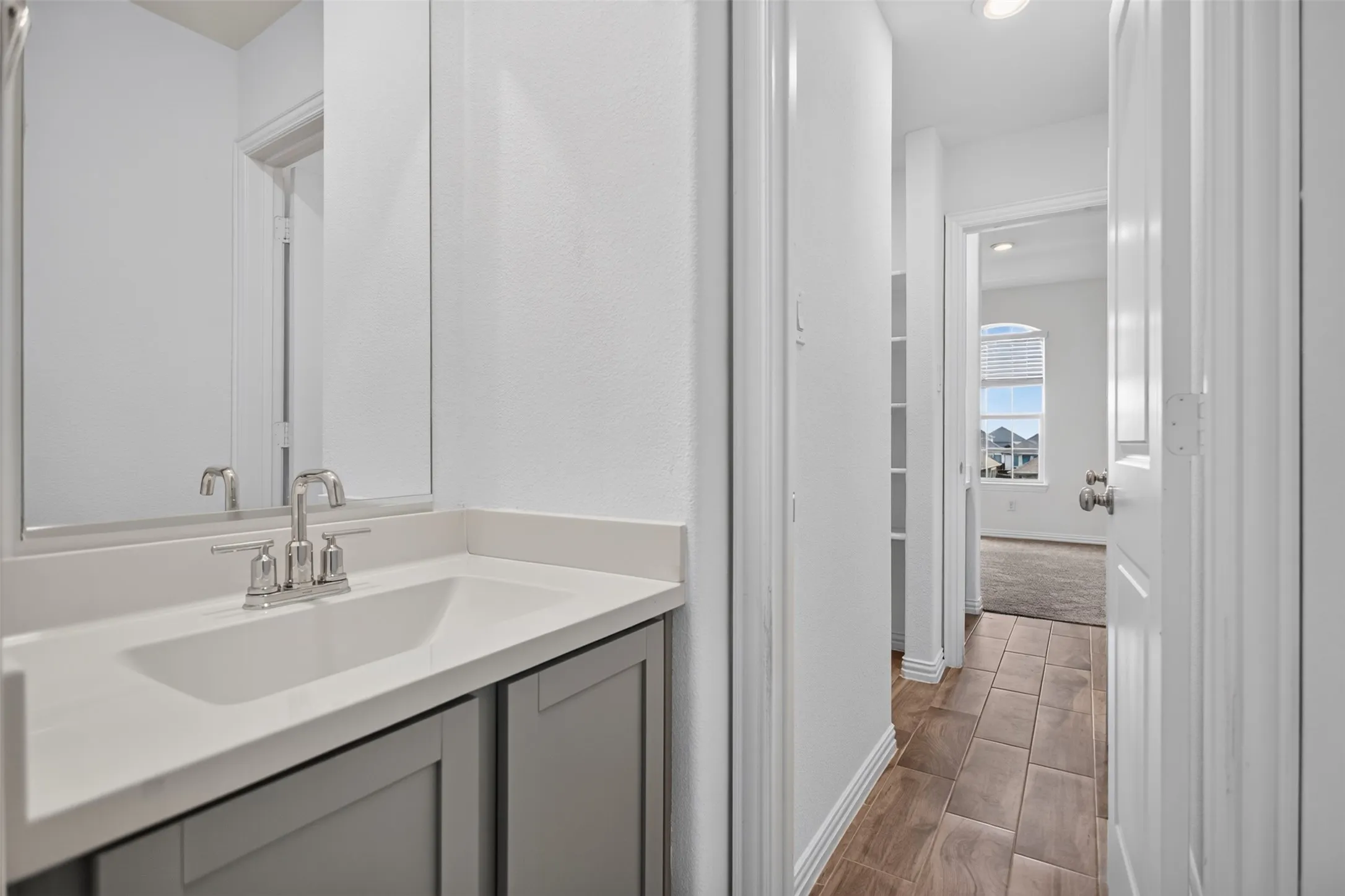 Vanity with an integrated rectangular sink, polished chrome faucet, and gray cabinetry