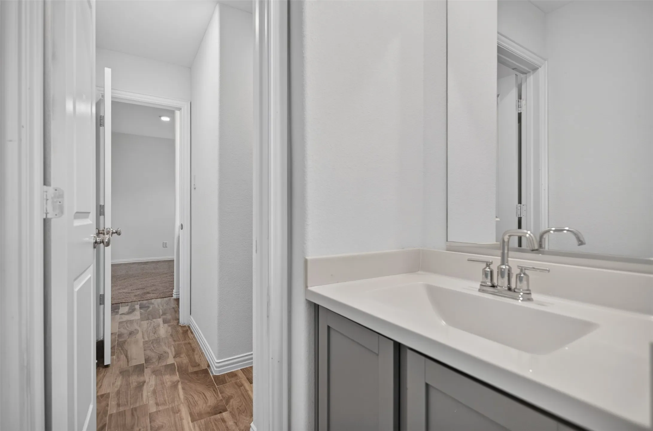Vanity with integrated sink, brushed nickel faucet, and gray cabinetry