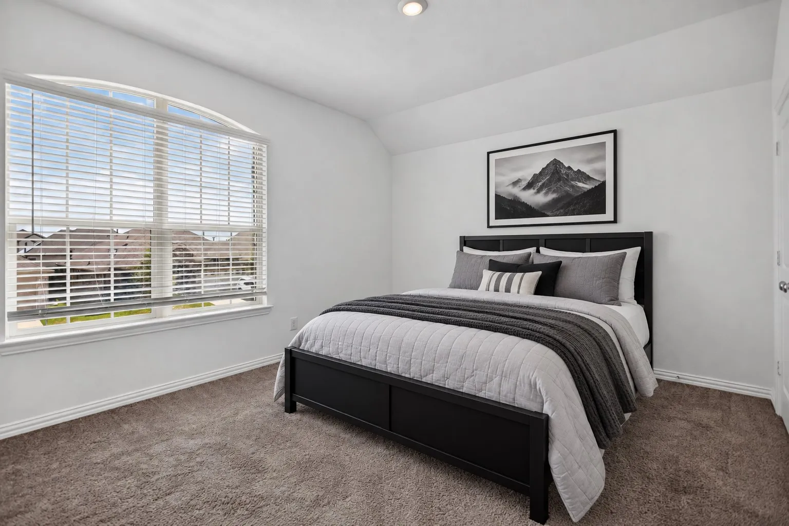 Arched window with blinds, recessed ceiling lighting, wall-to-wall carpeting, and a white interior door