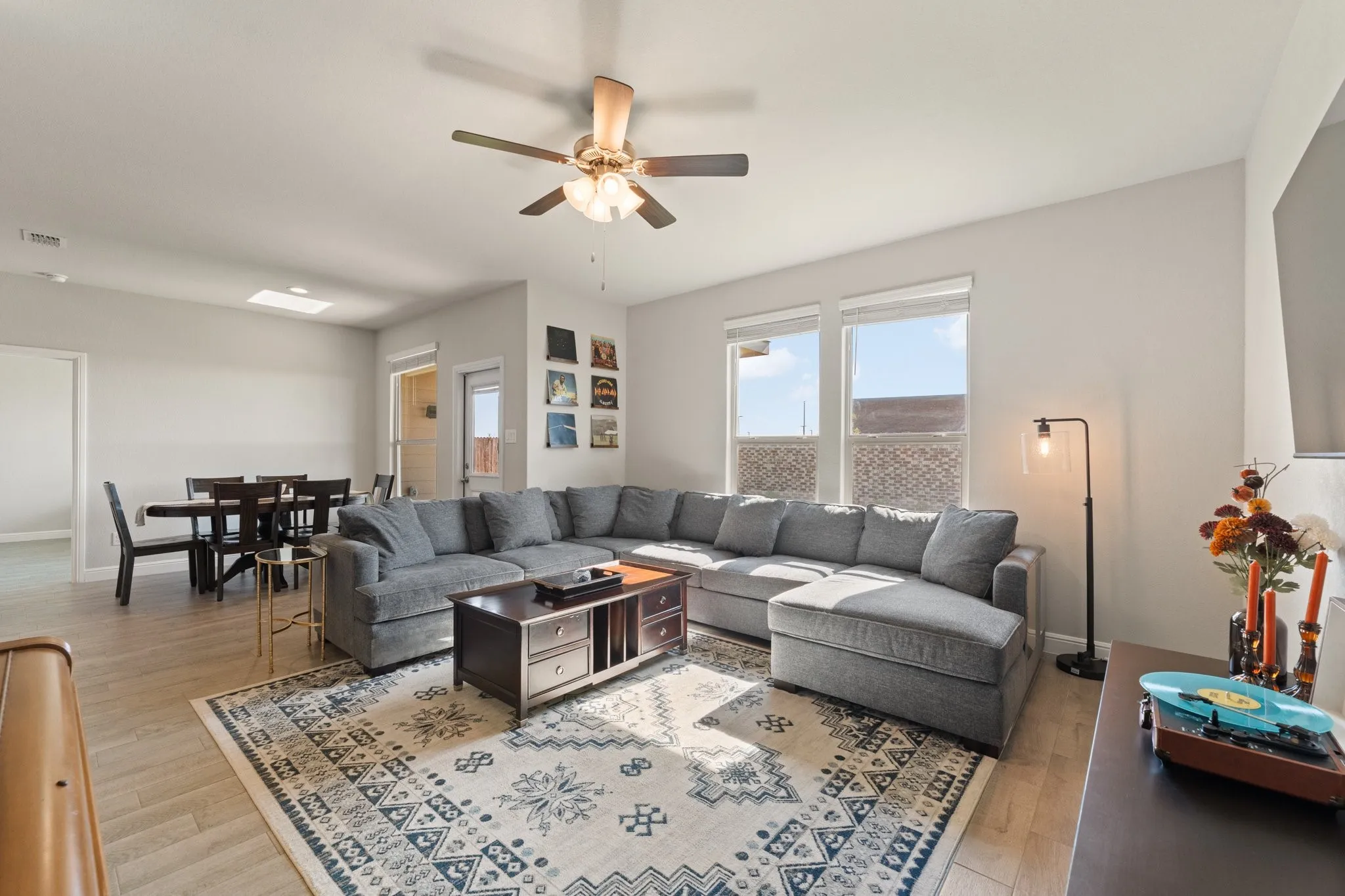 Open-concept living area with wood-finish flooring, recessed lighting, and a ceiling fan