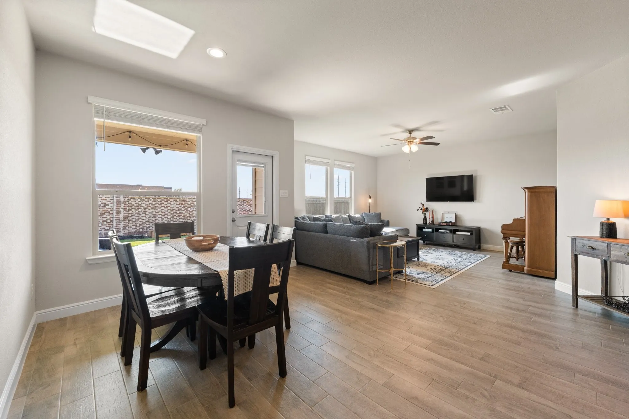 Wood-finish flooring throughout, recessed ceiling lighting, a ceiling fan with integrated lighting, and white trim
