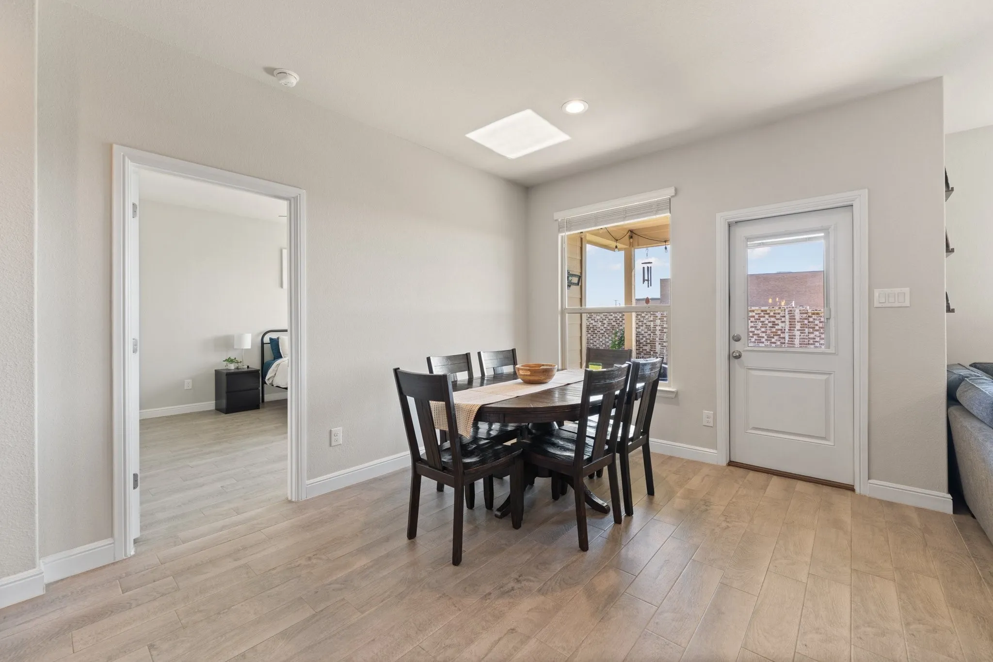 Light wood-finish flooring extending into an adjacent room