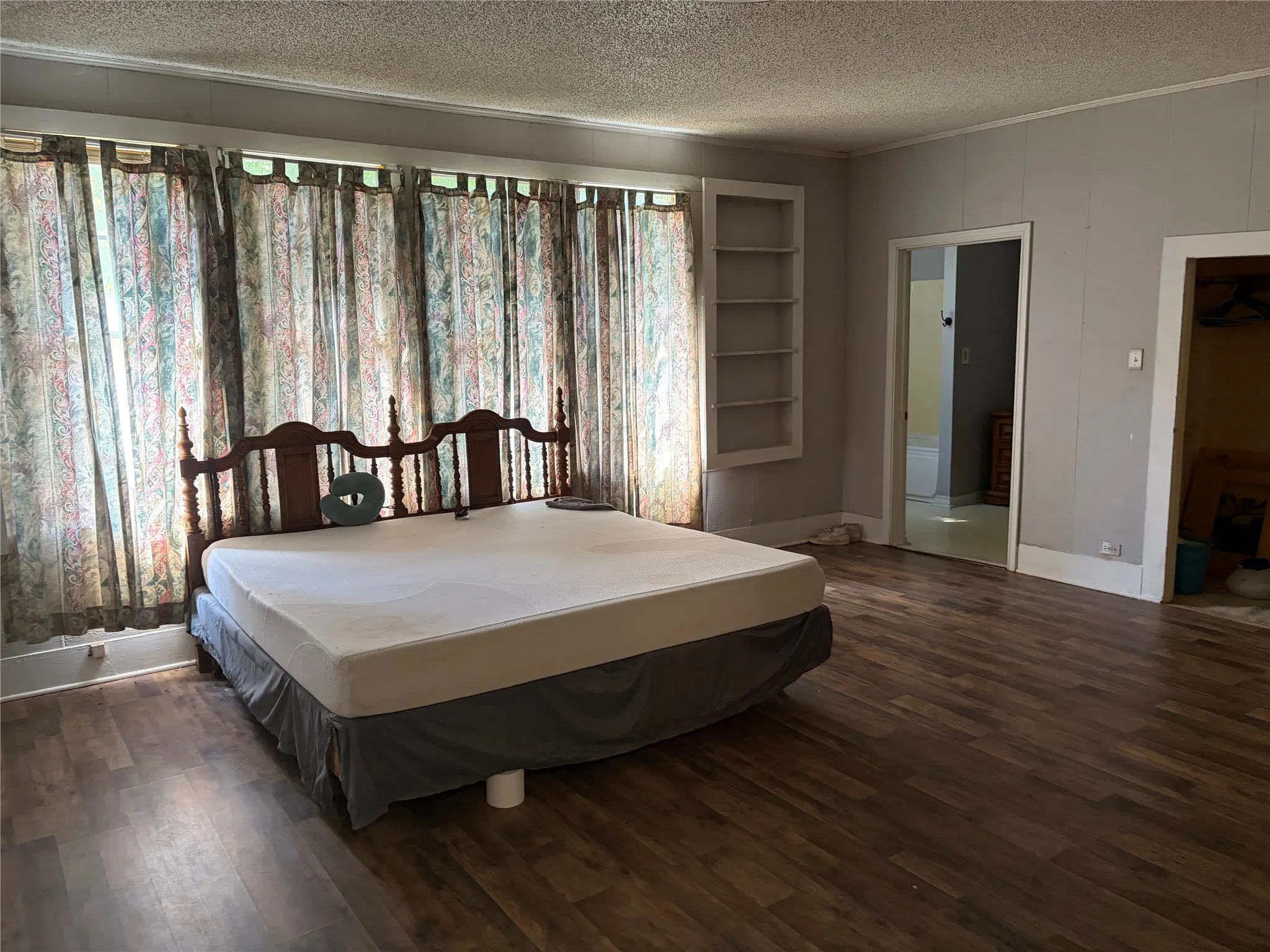 Wood-finish flooring, built-in shelving, and multiple door openings