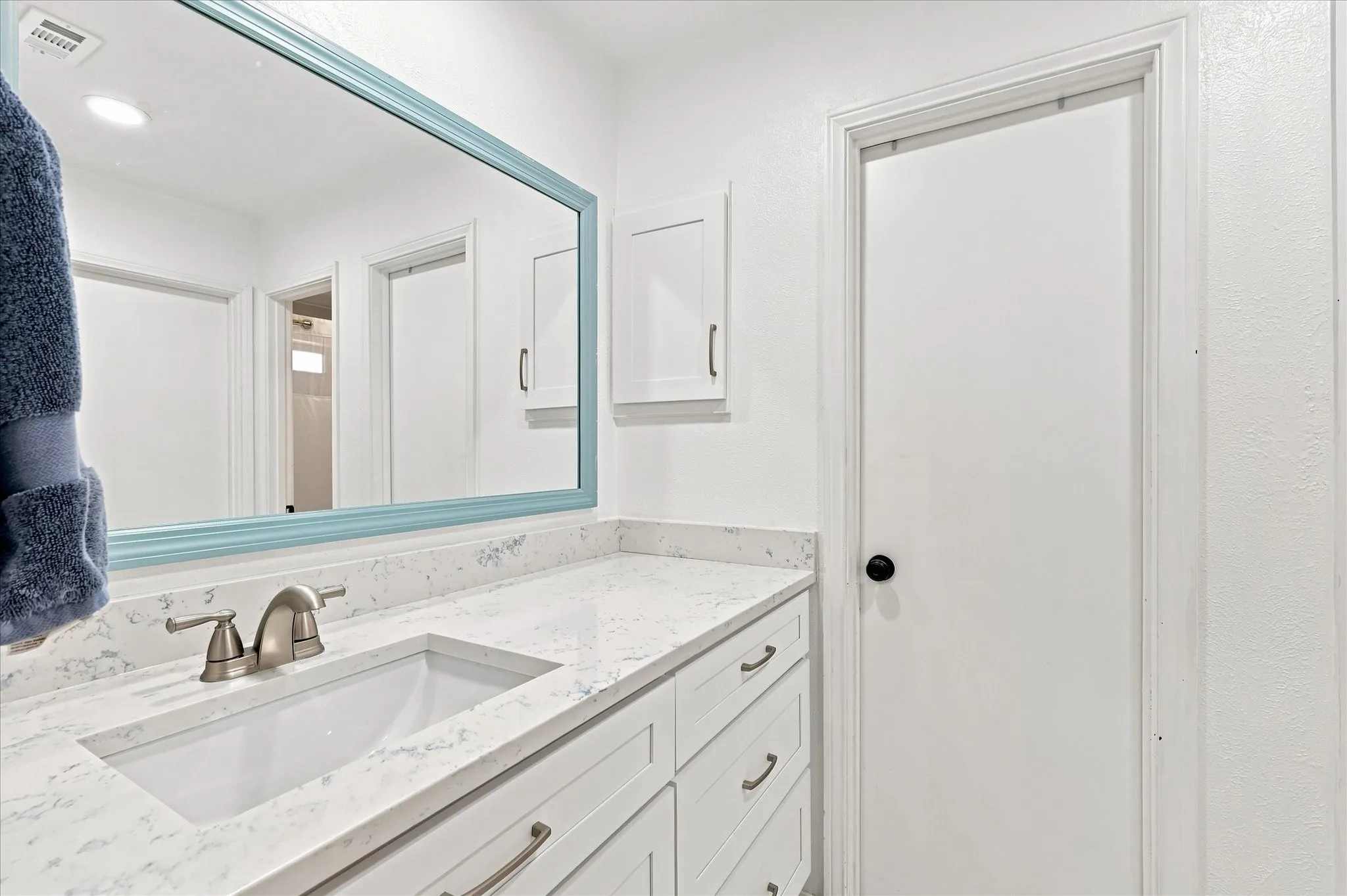 Updated primary bathroom with quartz countertops.