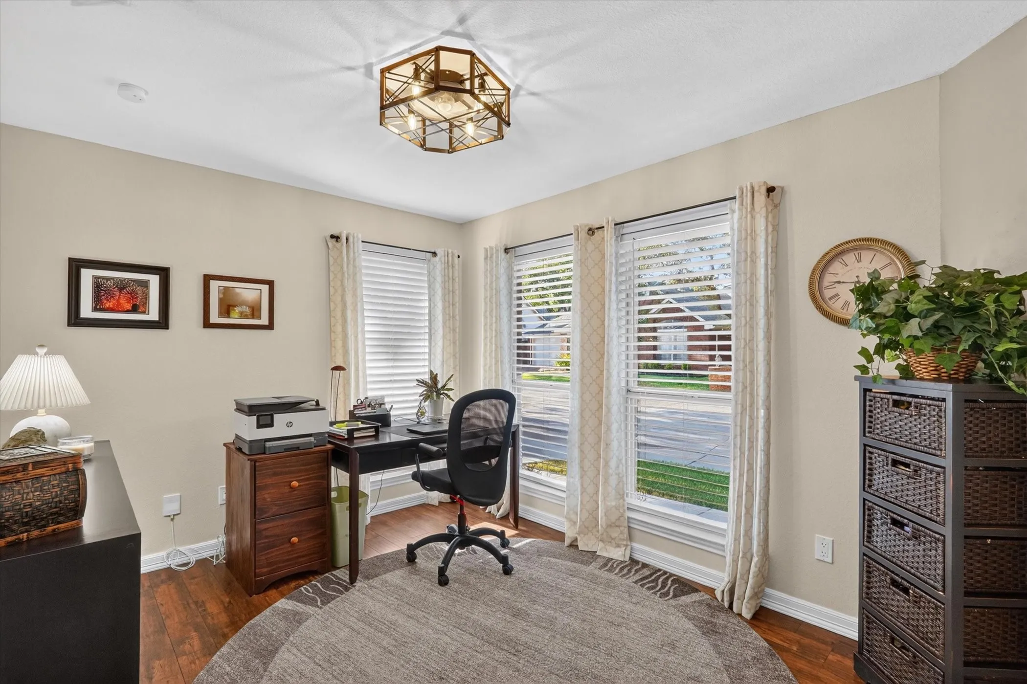 Room featuring wood-finish flooring, two large windows with blinds, and a built-in overhead light fixture