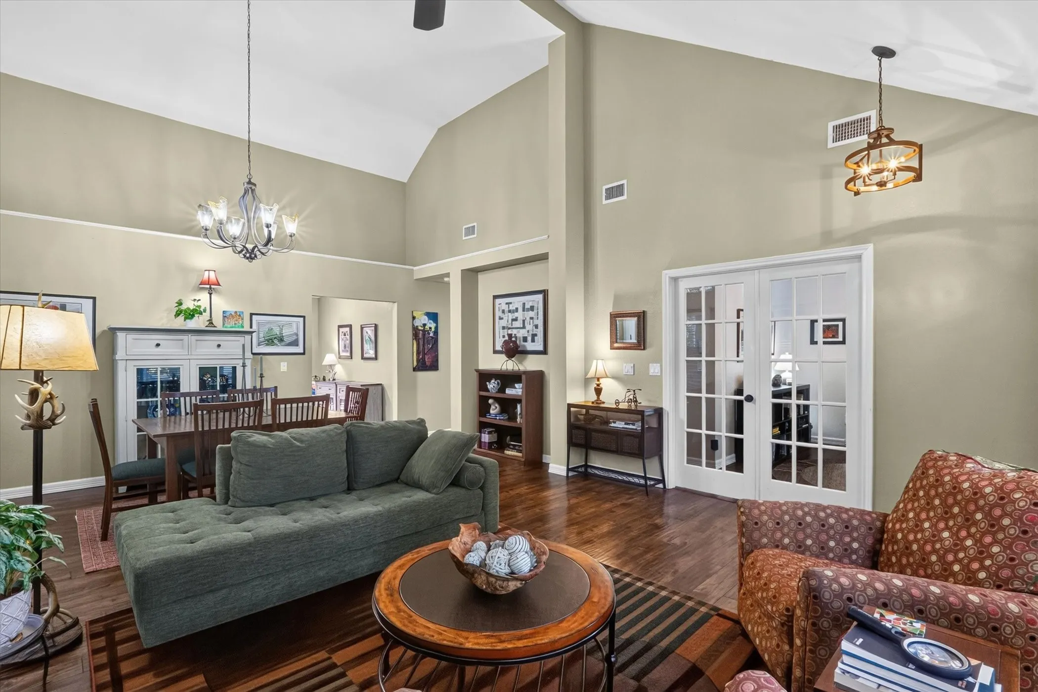 Vaulted ceiling with an exposed beam, wood-finish flooring, and French doors with glass panes
