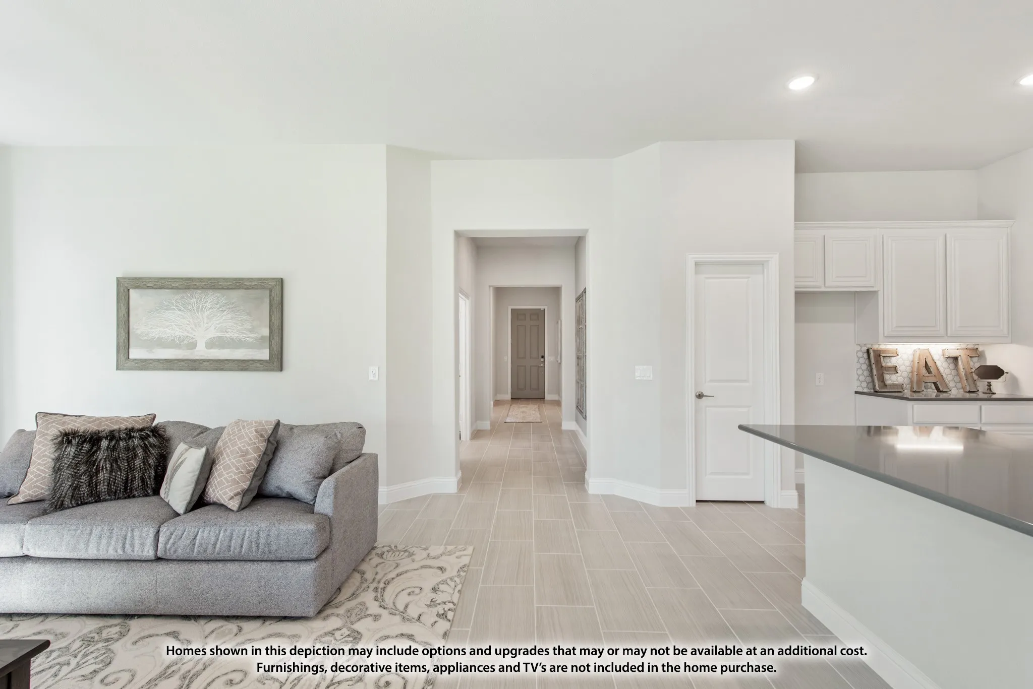 Wood-finish flooring throughout, recessed lighting, white panel doors, white cabinetry, and a dark countertop on the kitchen island