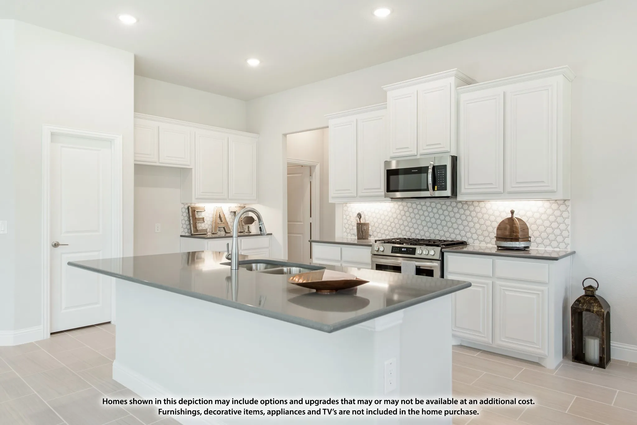 Kitchen featuring an island with an undermount sink, white cabinetry, light countertops, stainless steel appliances, and tile flooring