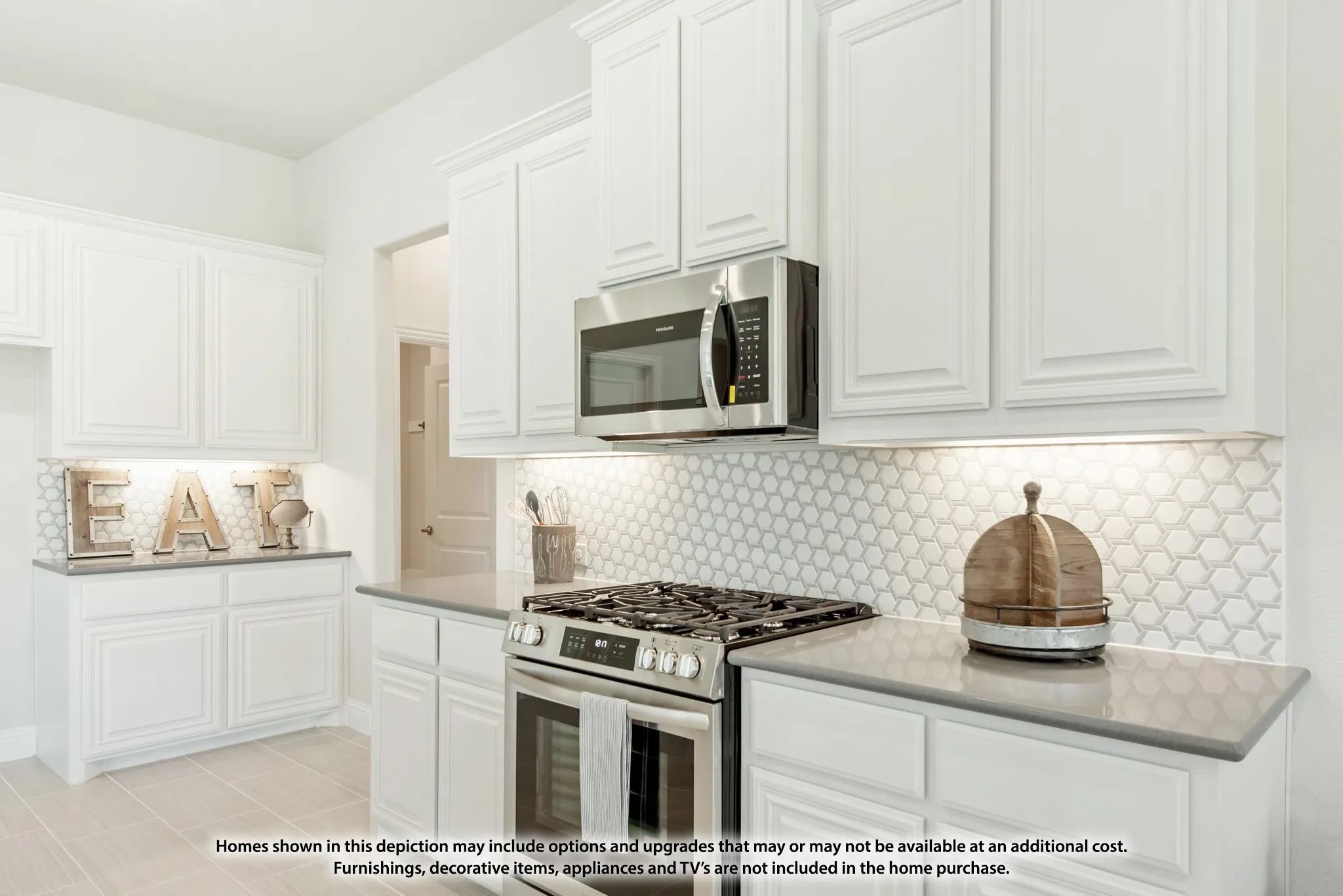 White shaker-style cabinetry, stainless steel oven with gas cooktop, built-in microwave, hexagonal tile backsplash, and light-toned countertops