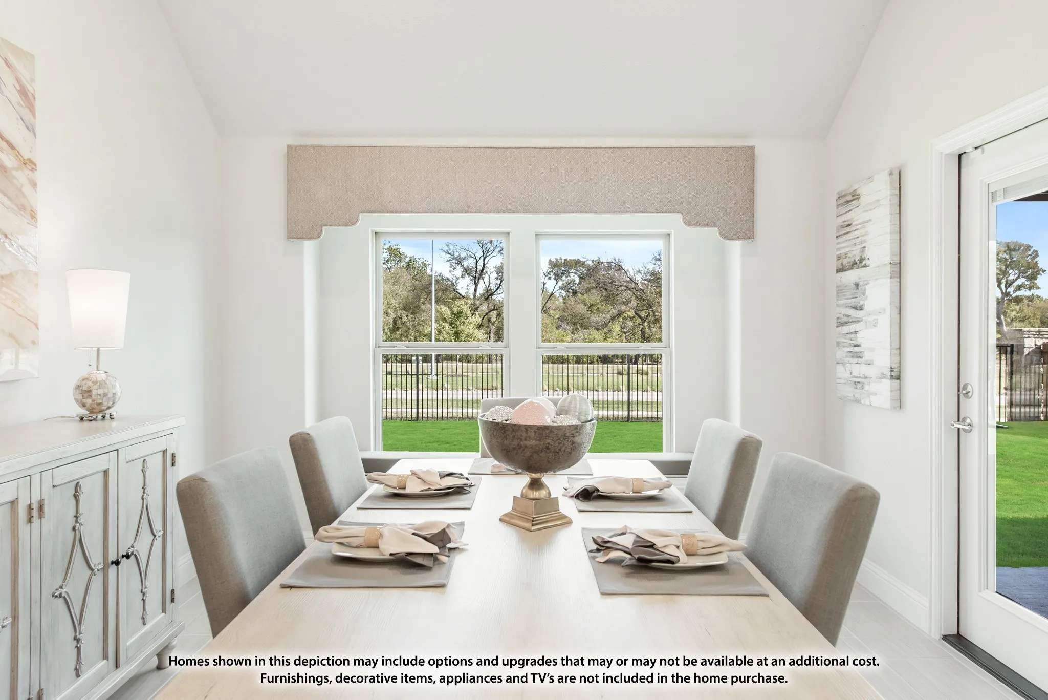 Bright dining area featuring a window with a valance, a built-in buffet with decorative hardware, and a glass-paneled door