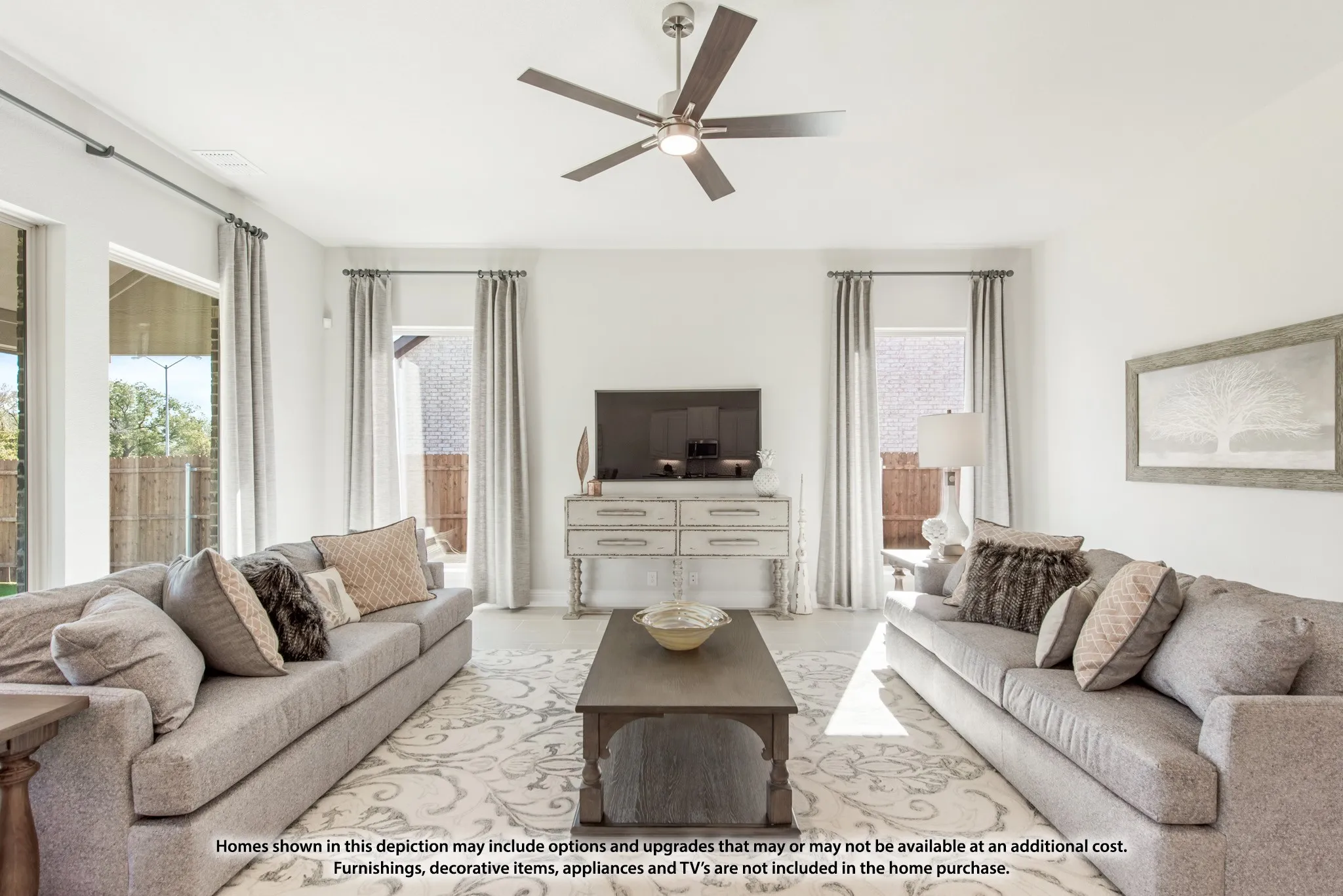 Bright living area featuring large windows, a ceiling fan, and light-toned walls