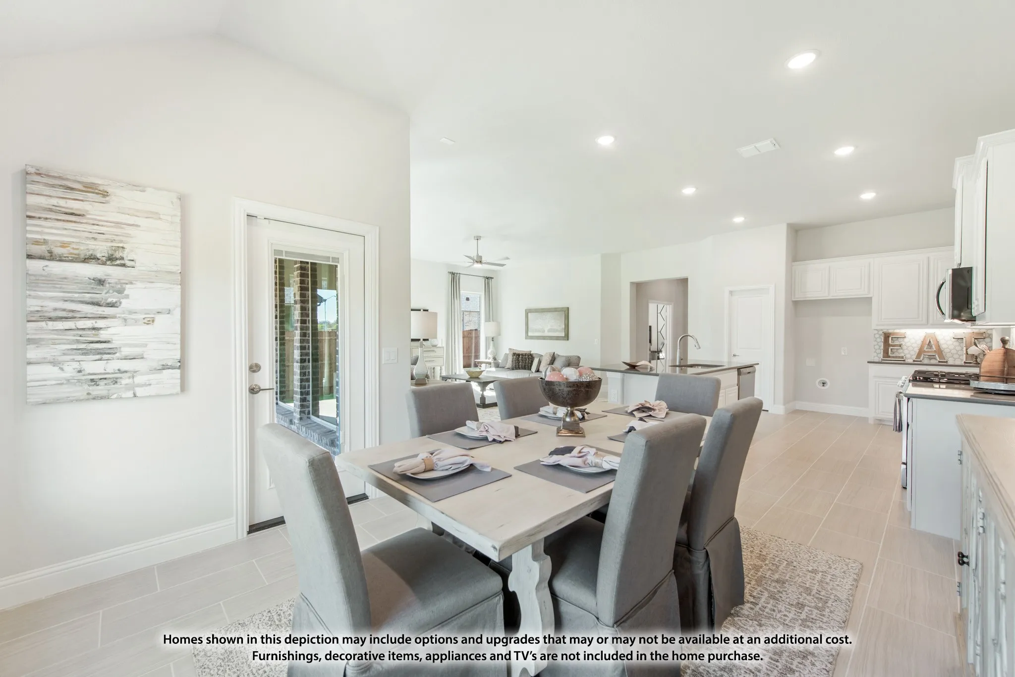 Vaulted ceiling in dining area, full-light exterior door, recessed lighting, tile flooring, and white kitchen cabinetry