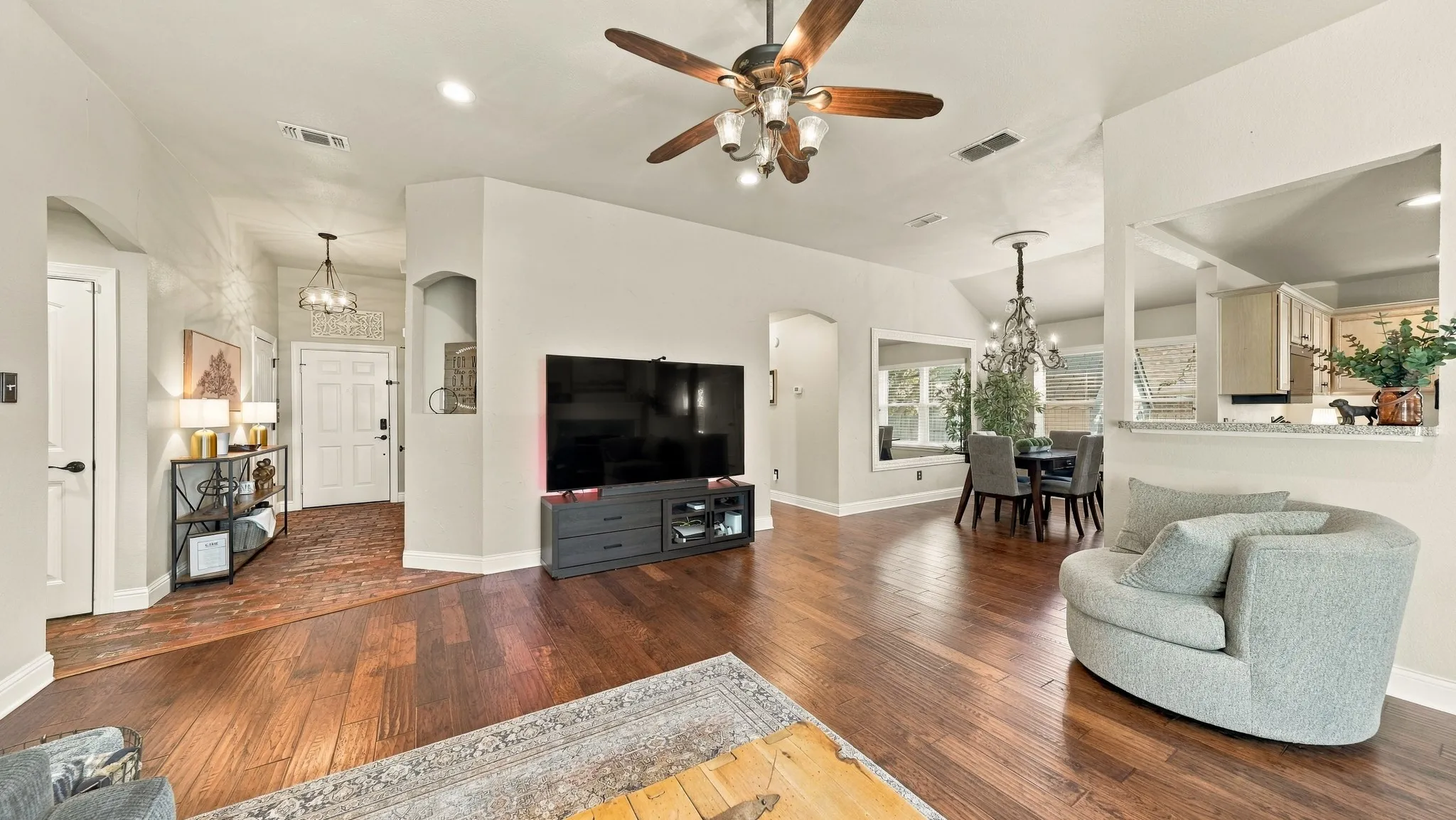 Wood-finish flooring throughout, vaulted ceiling, recessed lighting, and a contemporary ceiling fan with integrated lighting